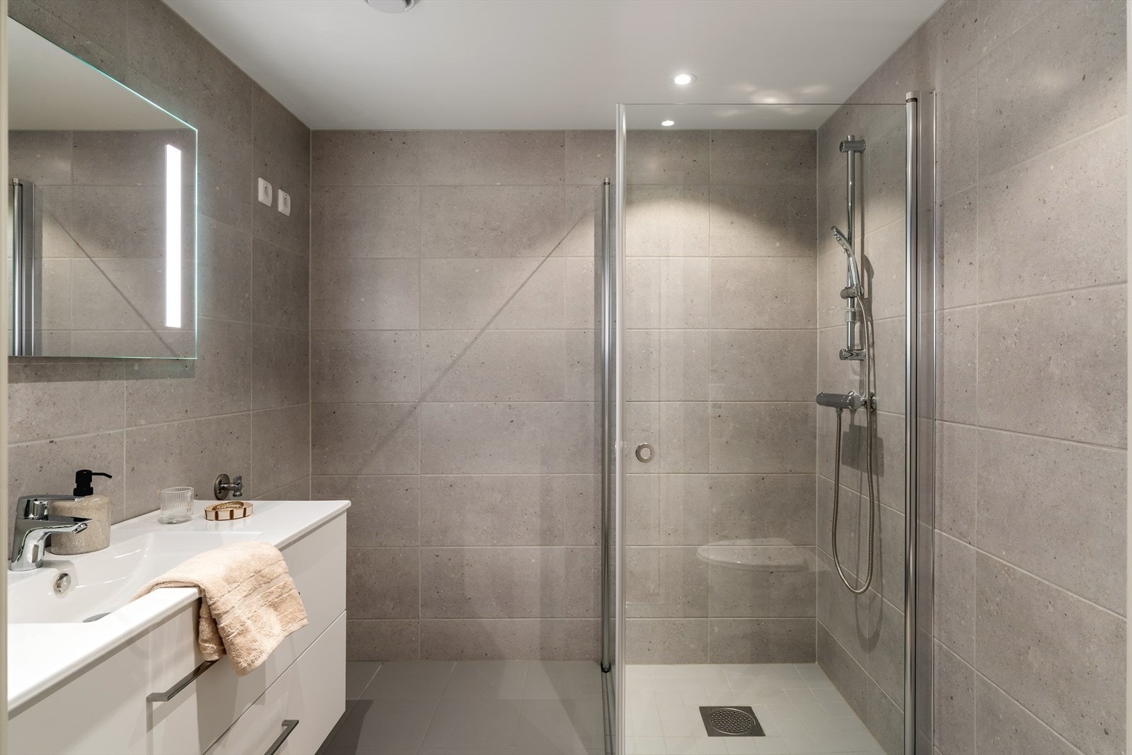 Lekkert, helfliset bad, innredet med vegghengt wc, seksjon med vask og dusjhjørne Galleribilde