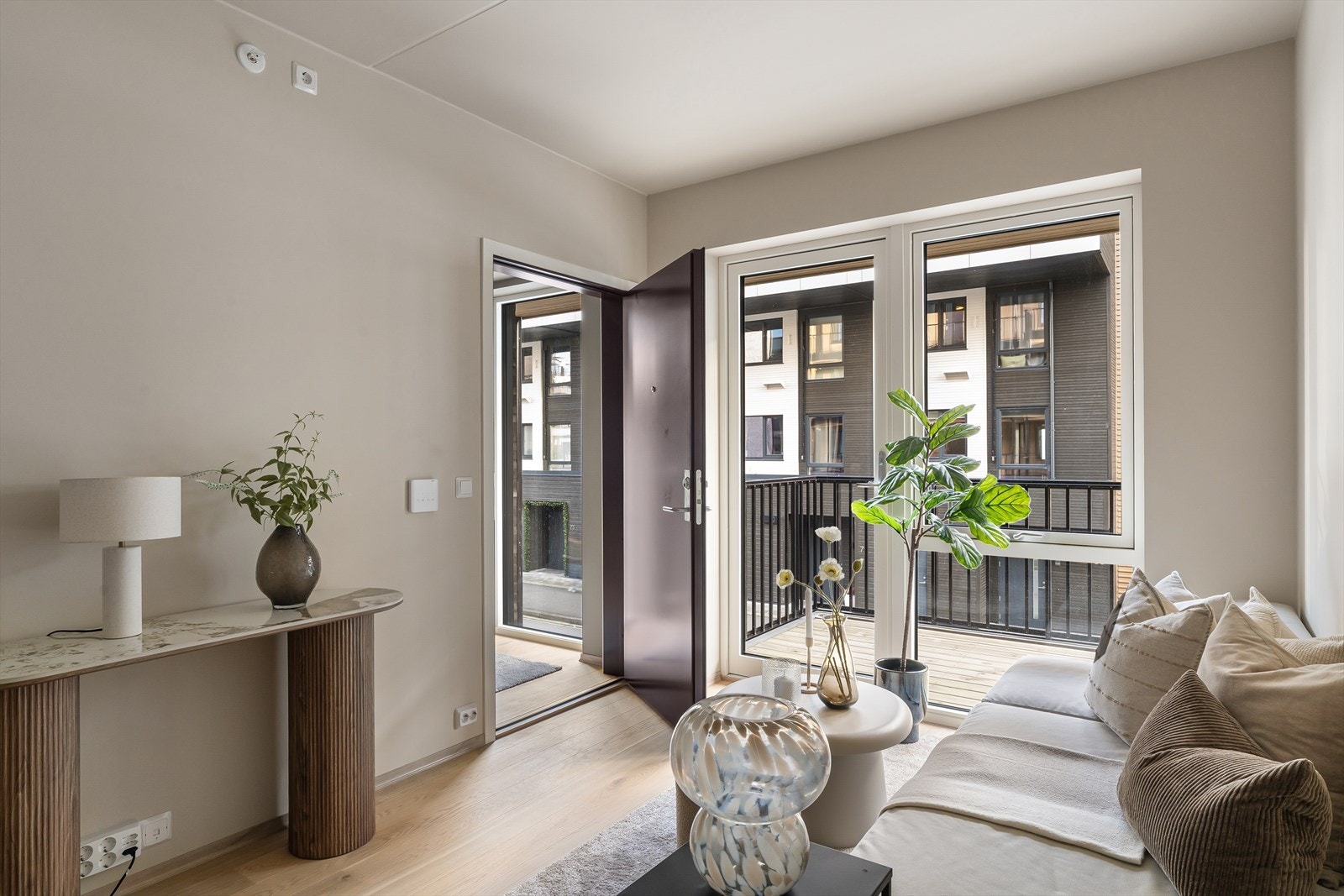 Stue og kjøkken i åpen løsning med plass til sovesofa og lite spisebord Galleribilde