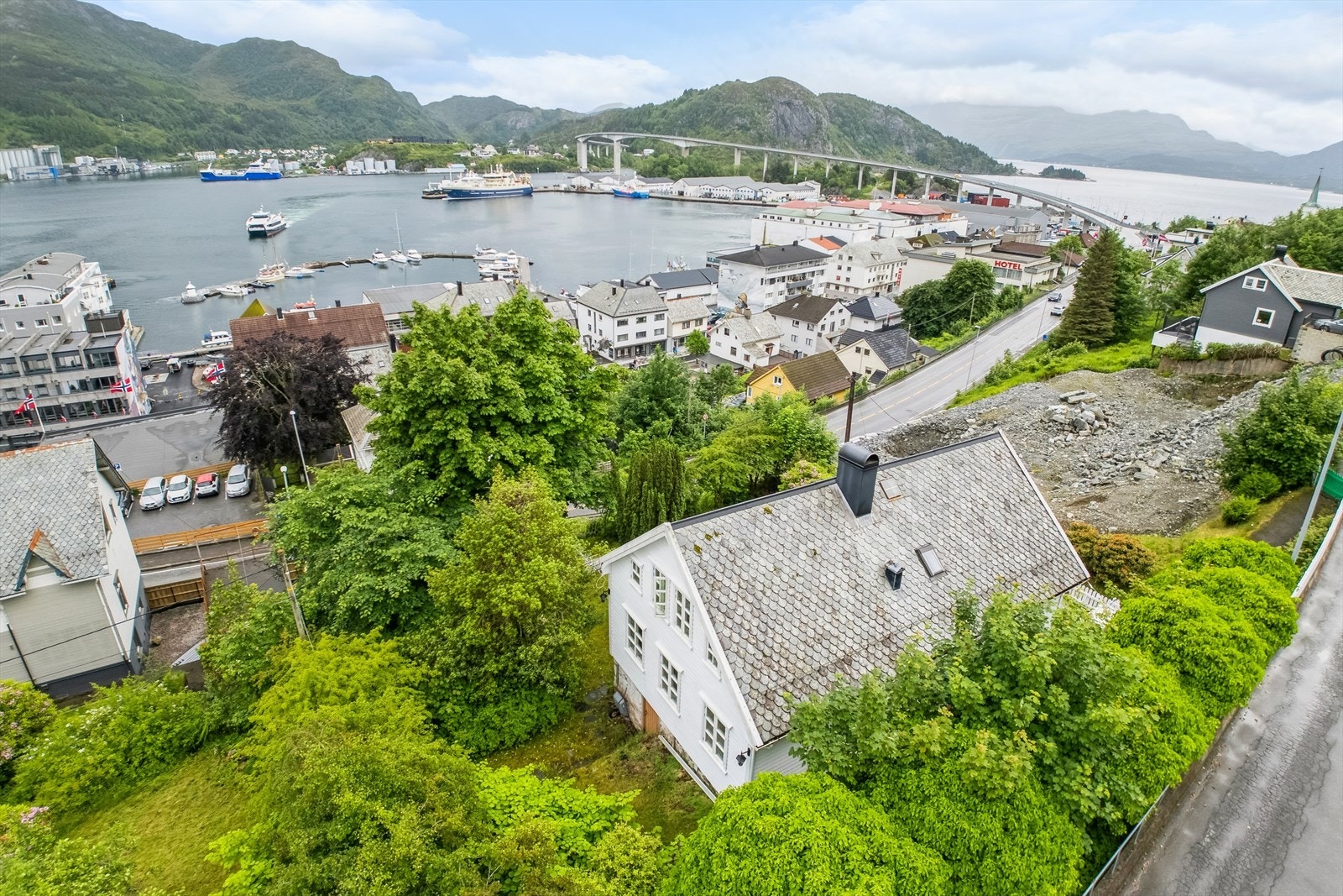 Boligen er omkranset av grønne trær og busker som gir lite innsyn Galleribilde