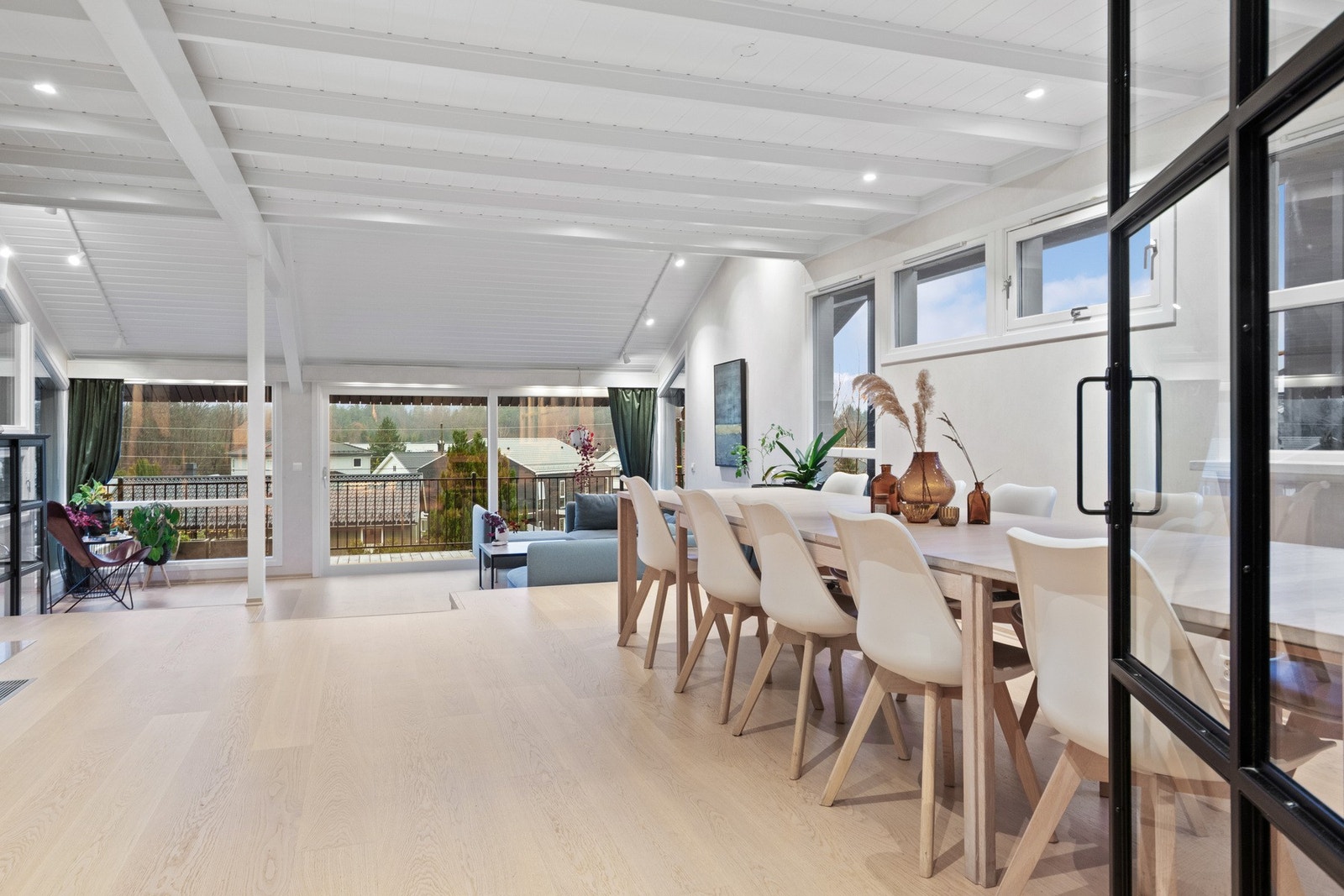 Uttrykket er gjennomført, og inn til kjøkkenet har stuen en stilig glassdør i sort innramming Galleribilde