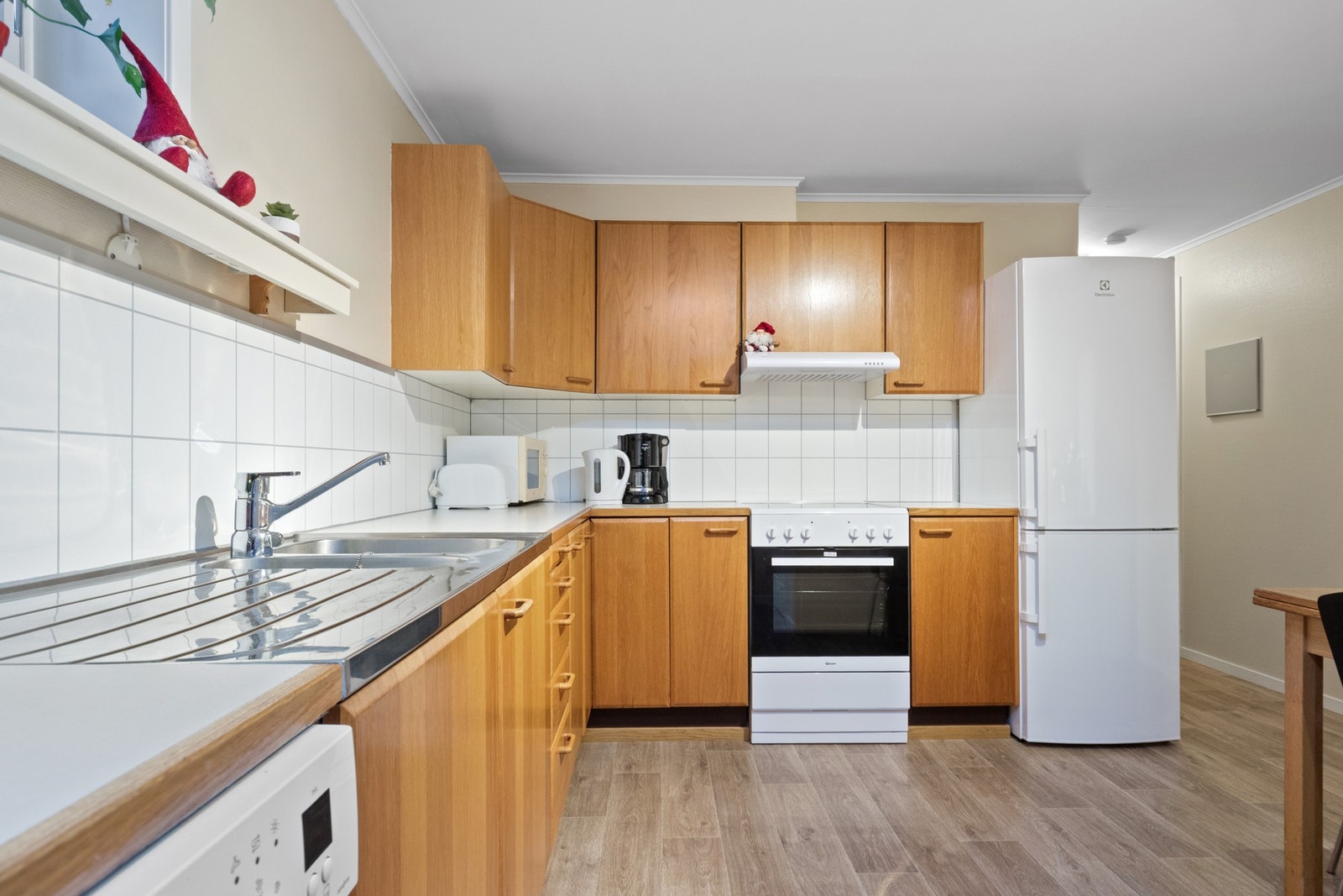 Selve kjøkkenet er oppført i en funksjonell L-form med god arbeidsflyt og skapplass Galleribilde