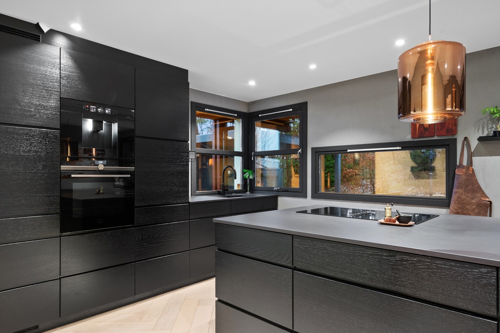 Veggene er malt i lysegrått og en trendy minttone, og kjøkkenet har store arbeidsflater og rikelig med oppbevaring Galleribilde