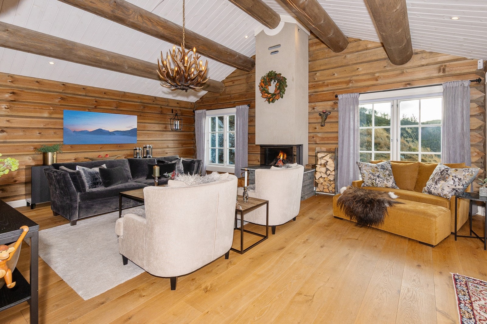 Stue med peis og mye naturlig lys inn fra store vinduer. Galleribilde