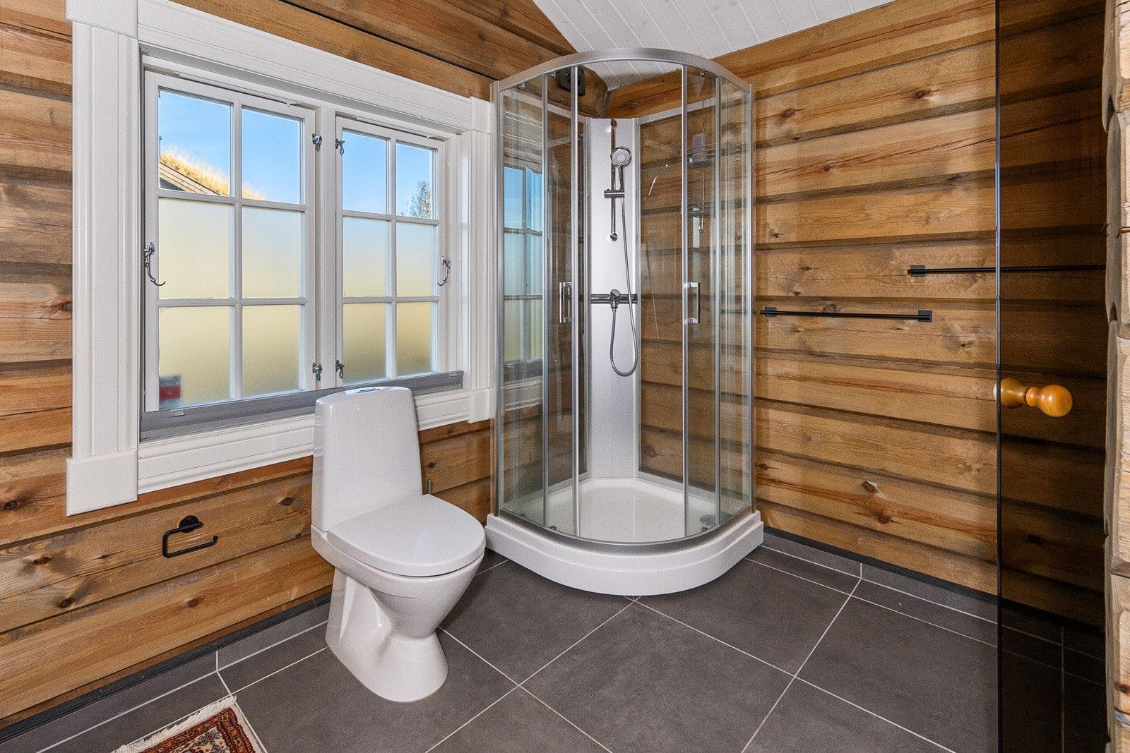 Bad har flis m/varmekabler, wc, servant i seksjon og dusjkabinett. Galleribilde