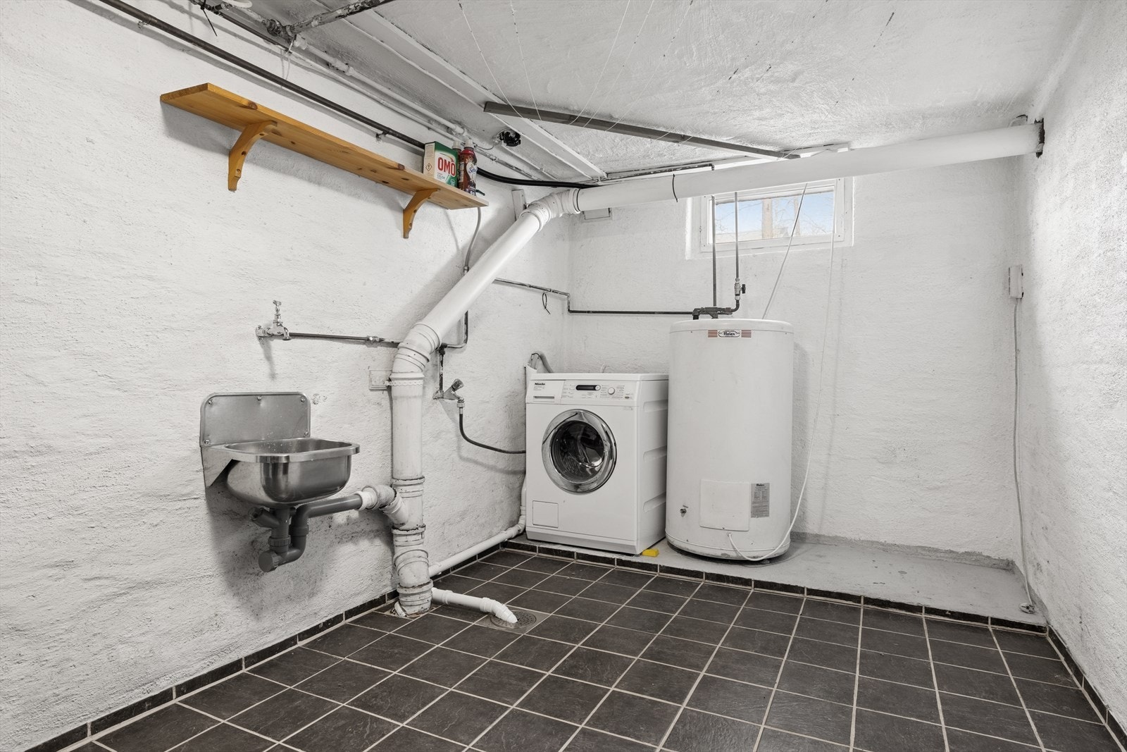 Vaskerom/teknisk rom med blant annet varmtvannstank er plassert i kjelleren. Galleribilde
