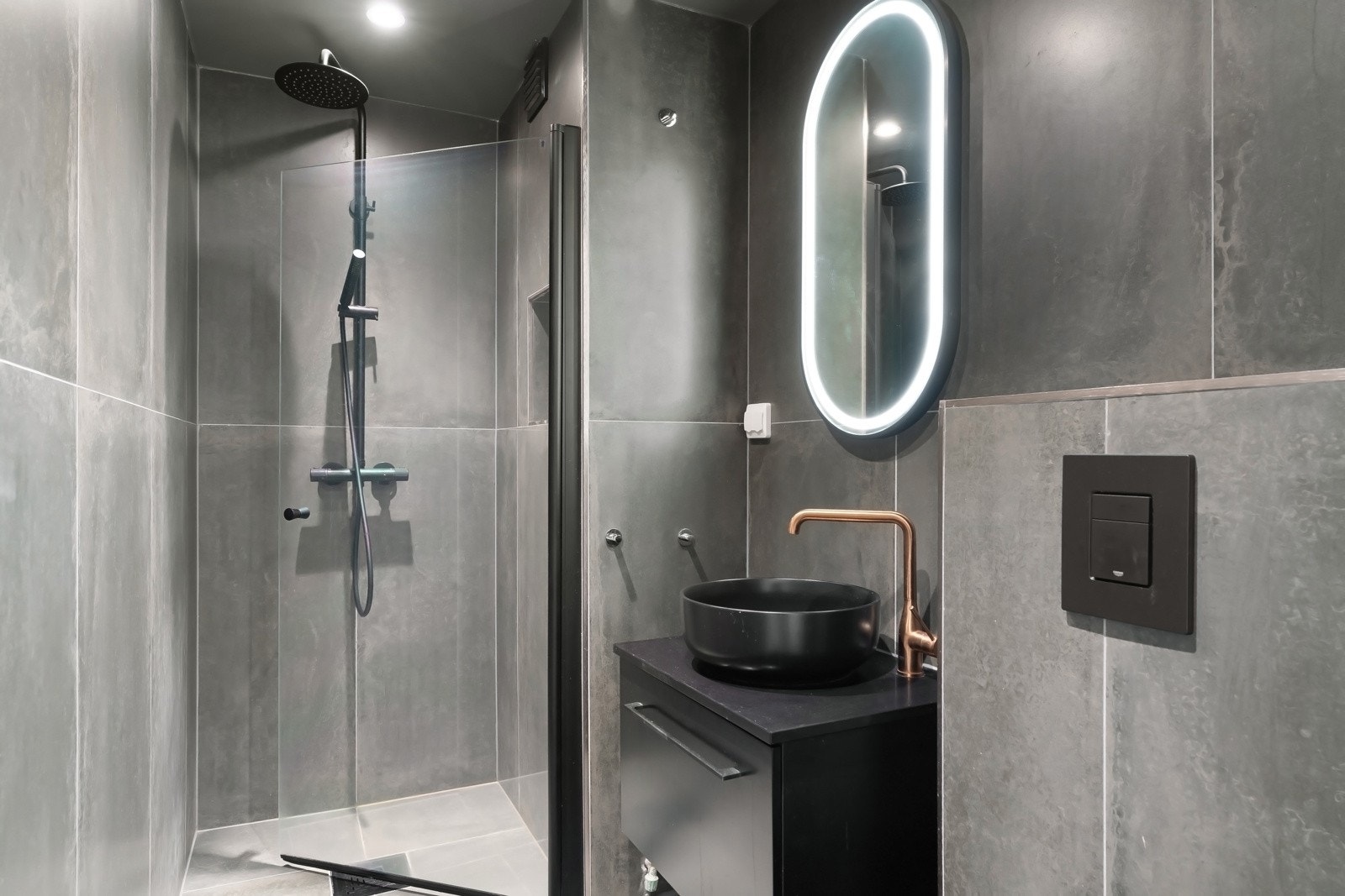 Lekkert baderom 2 med mørker fliser og varme i gulv. Galleribilde