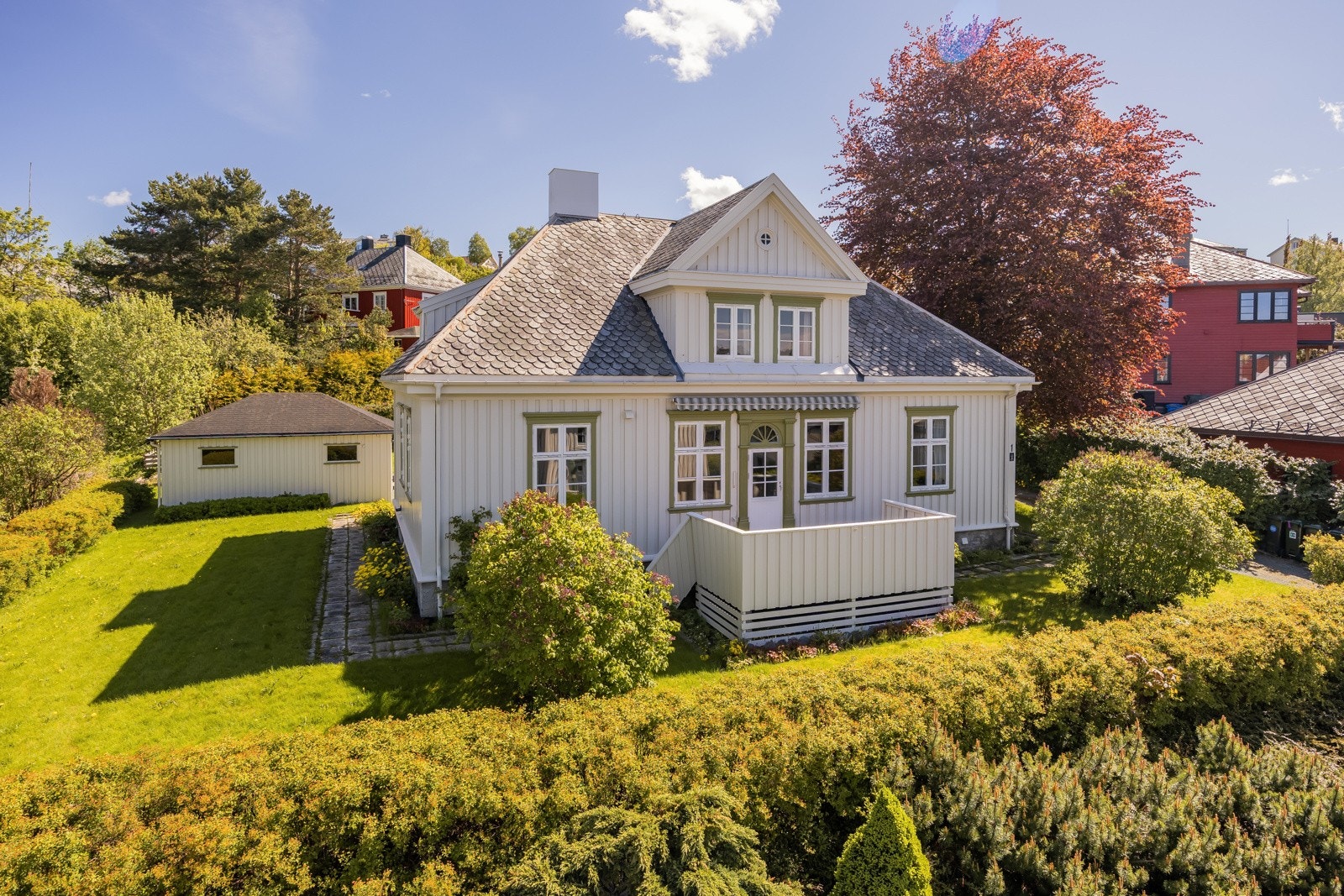 Eiendommen utgjør drøye 1,2 mål, og byr på en luftig bofølelse med frodig hage og stor gårdsplass. Galleribilde