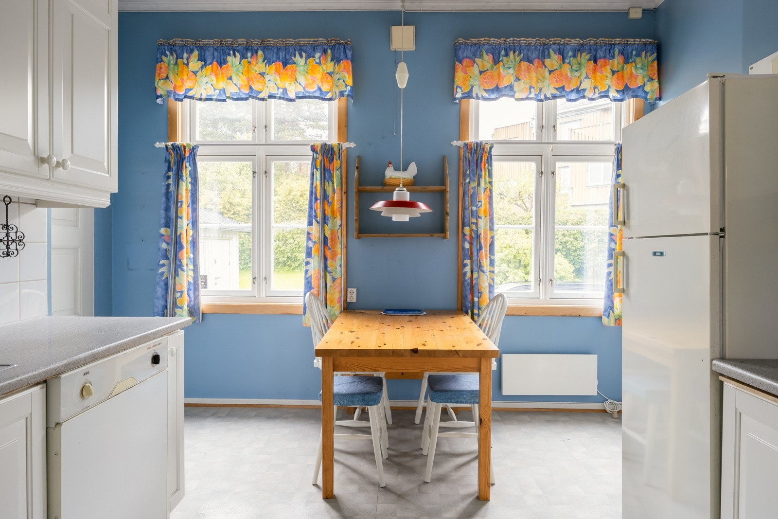 Doble kjøkkenvindu med utsyn mot den private gårdsplassen og hagen i bakkant av huset. Galleribilde