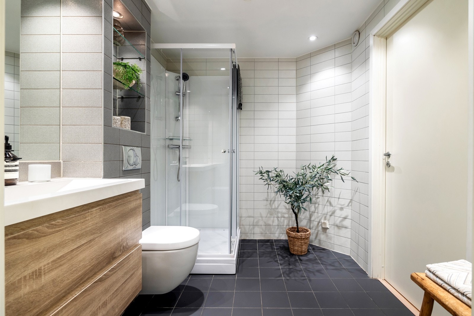 Rommet er utstyrt med dusjkabinett fra Otra, vegghengt toalett og servantinnredning i eik med skuffer og speil. Galleribilde