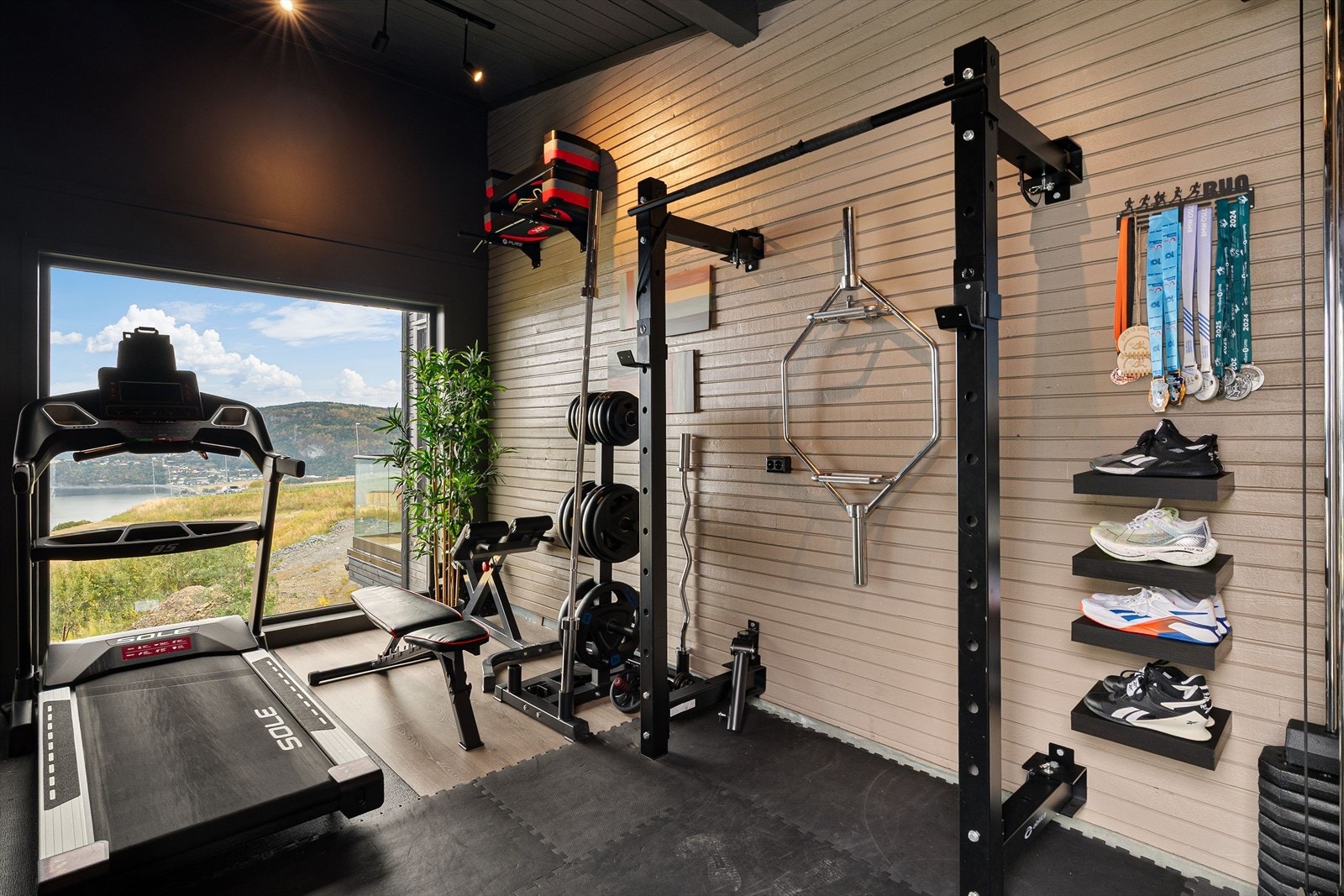 Tidligere carport er bygget om til et helhetlig og inspirerende treningsrom, med flott utsikt, solid gulv og plass til både styrke- og kondisjonsapparater. Galleribilde