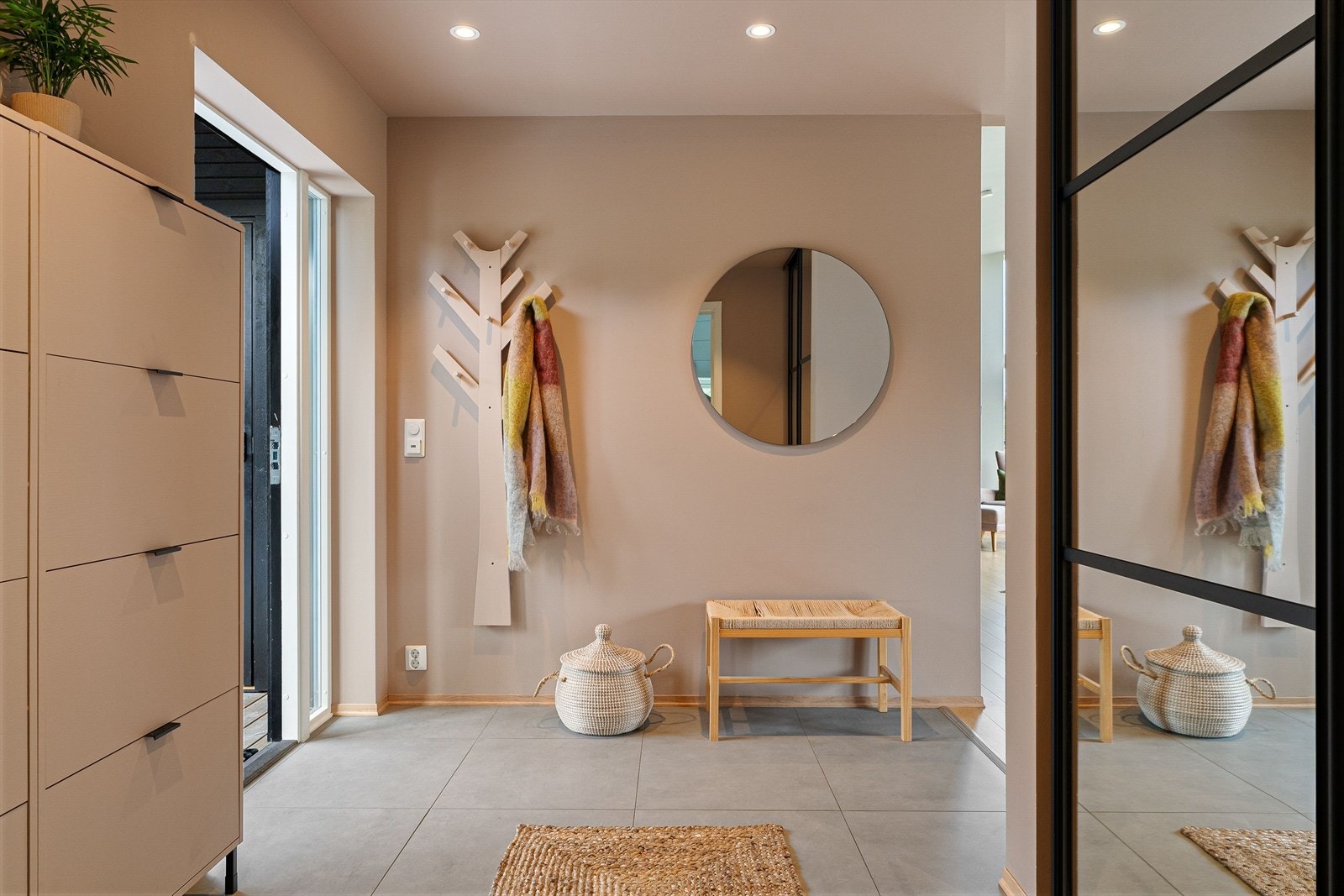 Rommet har flislagt gulv med varme, et moderne uttrykk og en innfelt skyvedørsgarderobe som holder yttertøyet på plass. Galleribilde