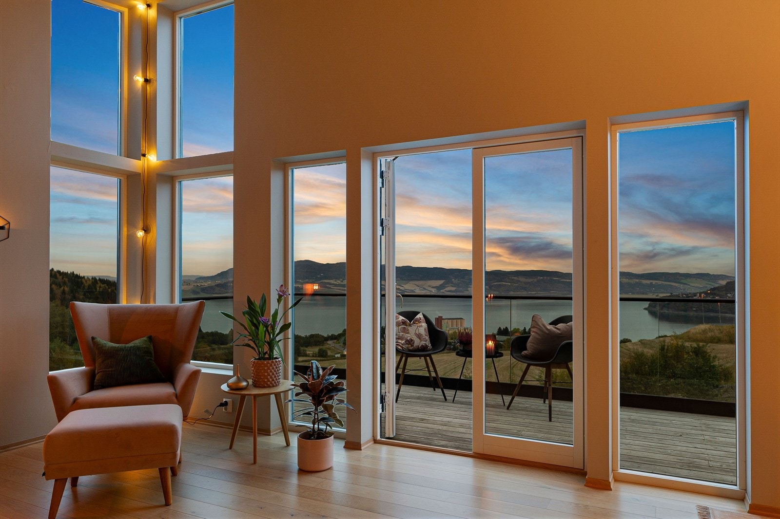 Stuen er et imponerende og luftig oppholdsrom med god takhøyde, store vindusflater og utsyn mot fjorden. Galleribilde