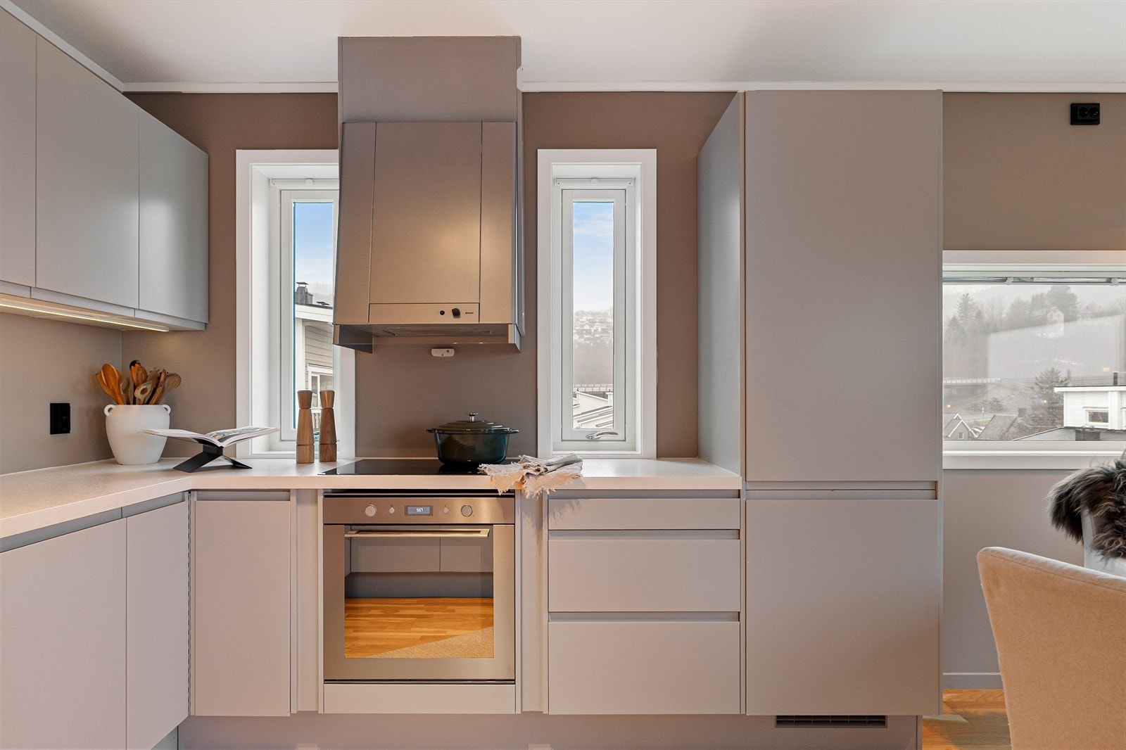 Innredningen har glatte, håndtaksløse fronter, hvit laminatbenkeplate og nedfelt oppvaskkum. Galleribilde