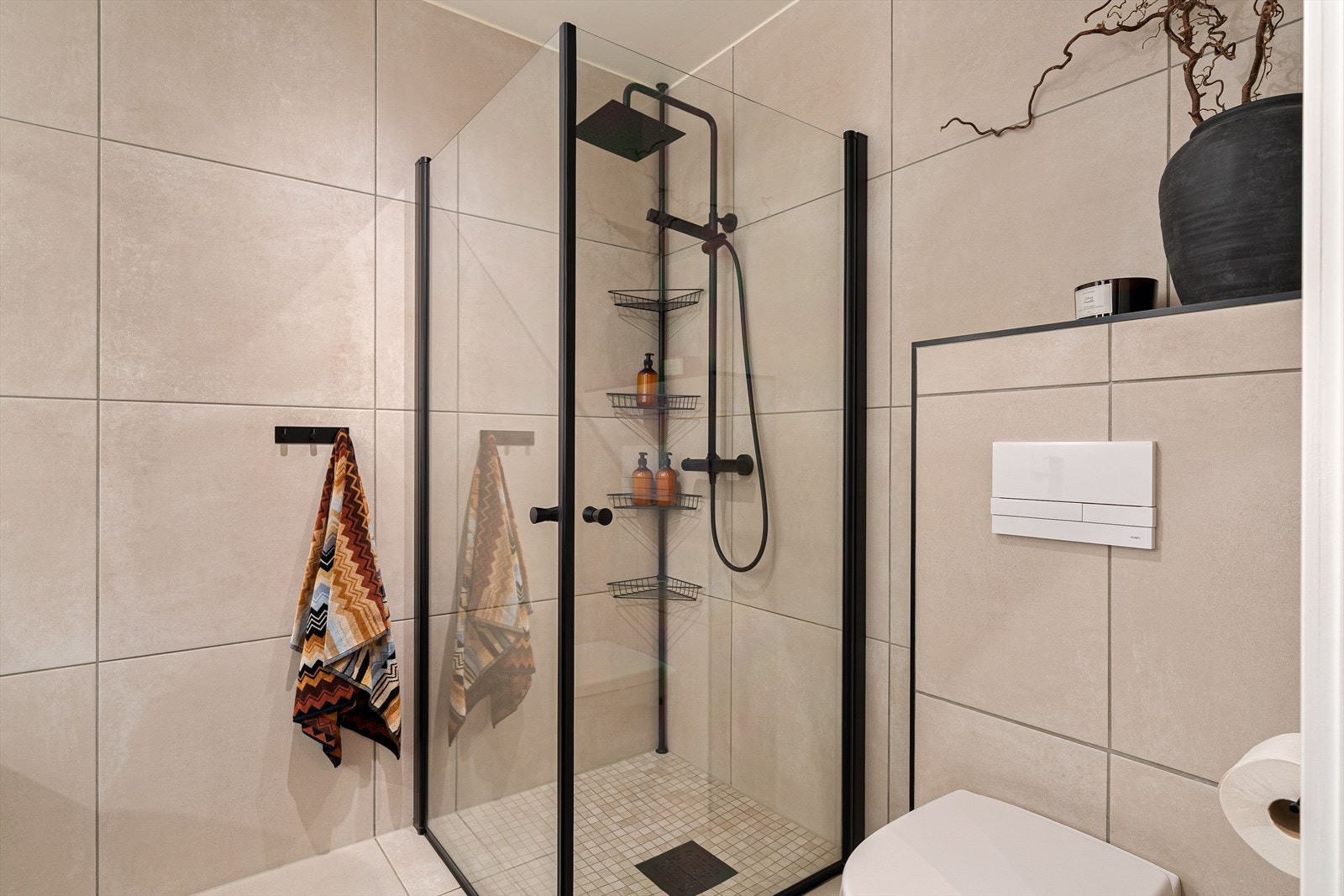 Regnfallsdusj og et dusjhjørne med innfellbare glassdører gir ekstra hverdagsluksus. Galleribilde