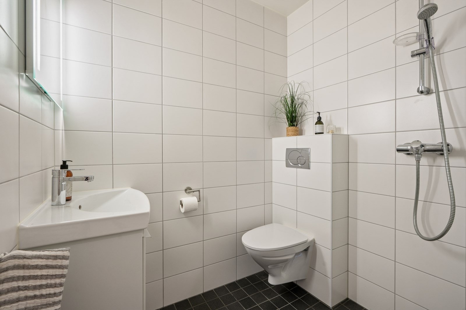 Bad i 2. etasje med vegghengt toalett, servant med skuffeløsning under og dusj. Galleribilde