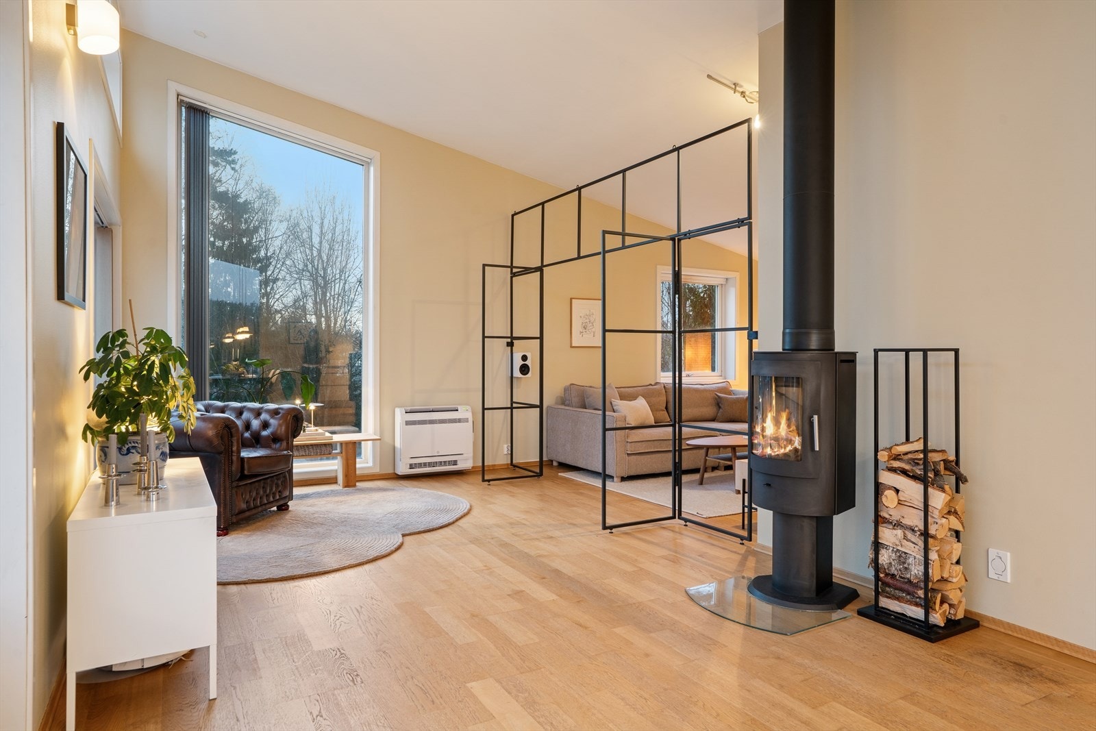 Delikat stue med flere soner. Generøs takhøyde. Monter varmepumpe i 2024 i tillegg til at det er peisovn for kos. Galleribilde