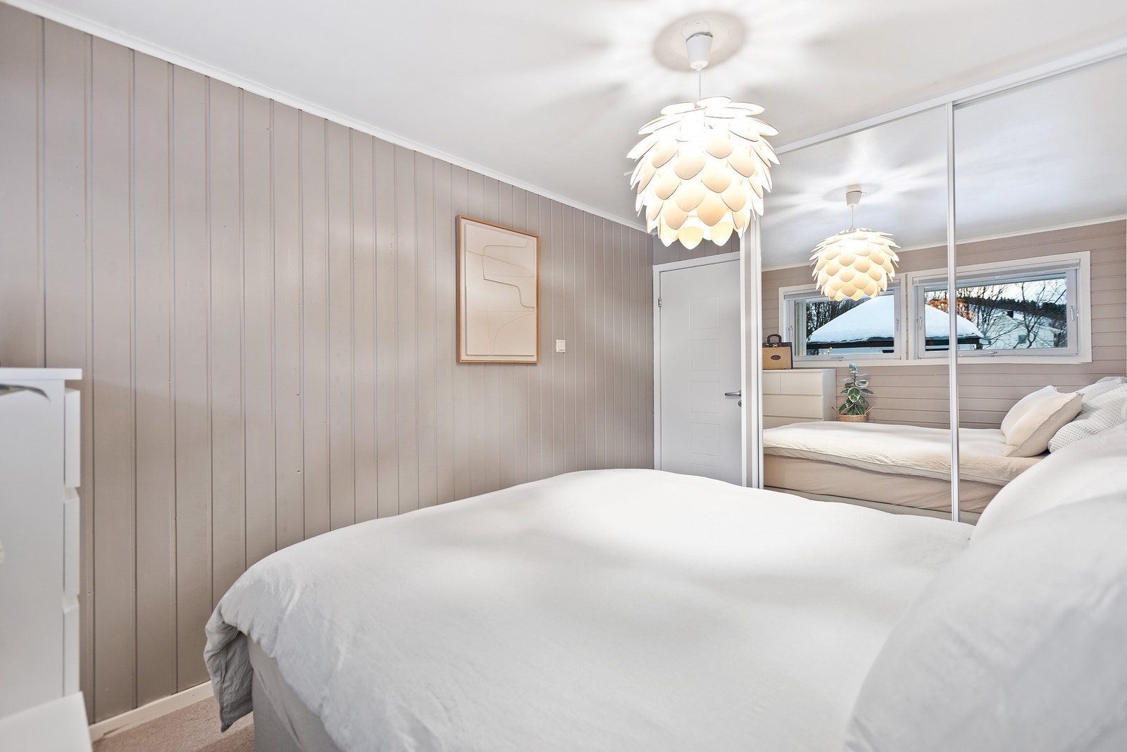 Speilskyvedørsgarderoben bidrar til et ryddig uttrykk og reflekterer lyset, noe som gjør rommet luftiger Galleribilde