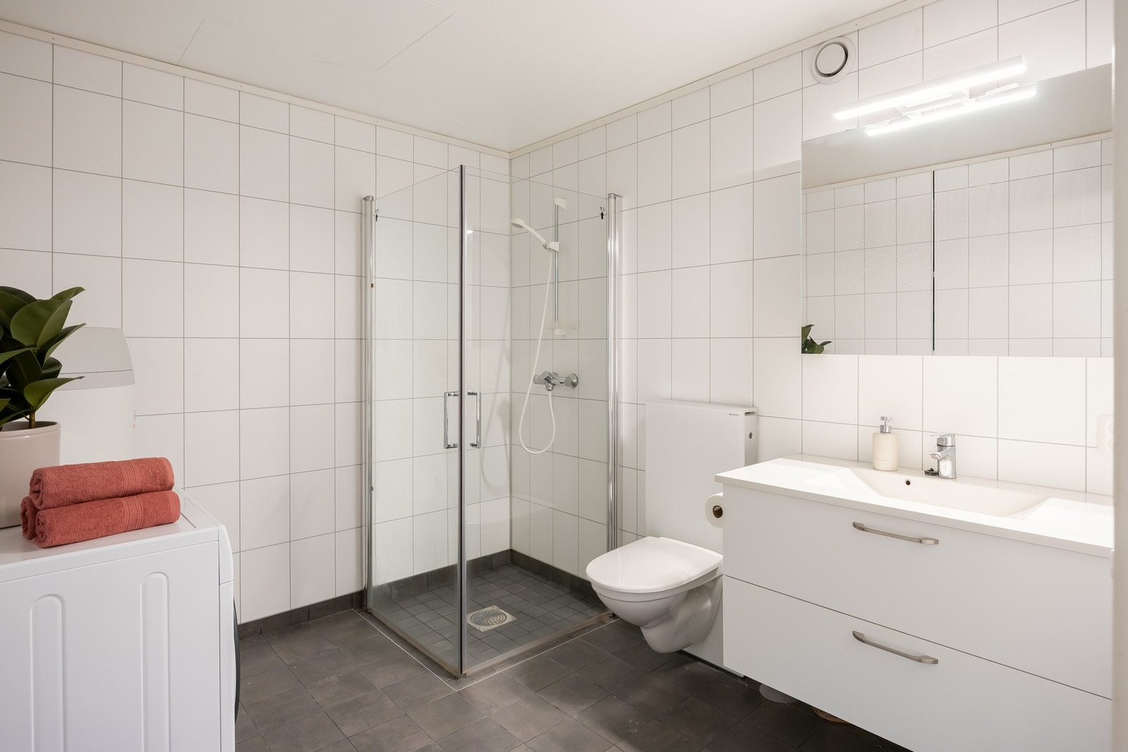 Badet fremstår moderne og stilfullt. Flislagte vegger og gulv samt varmekabler. Galleribilde