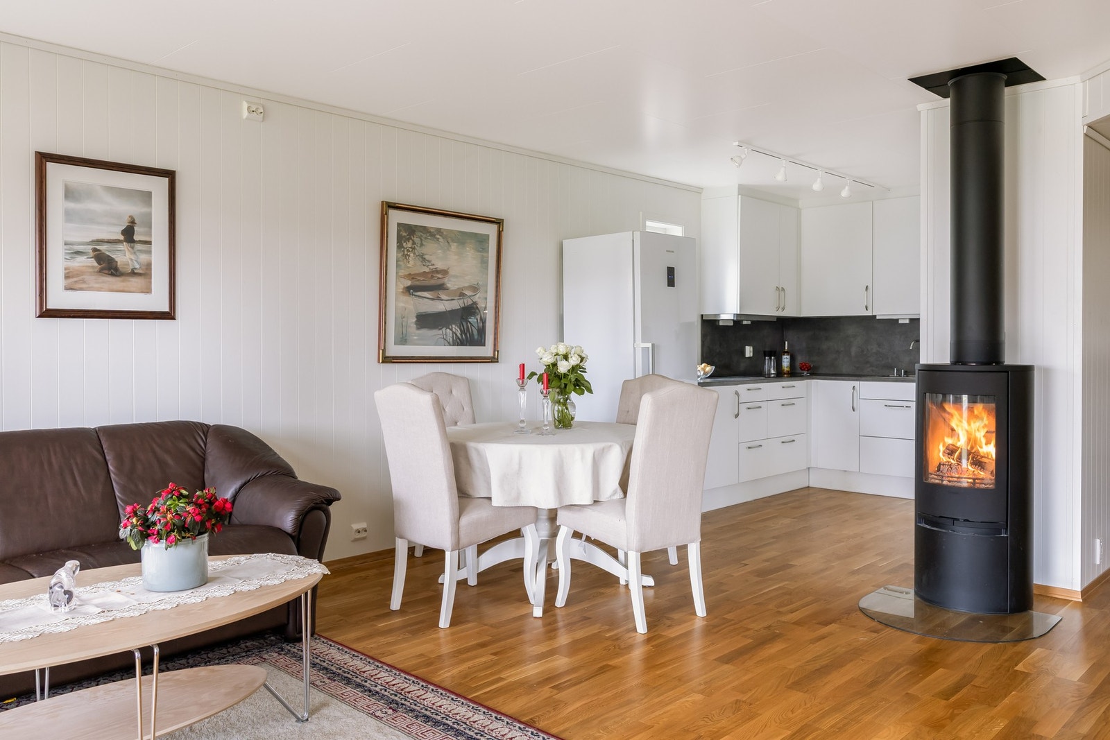 Stuen er utstyrt med både vedovn og varmepumpe, noe som gir effektive og fleksible oppvarmingsmuligheter Galleribilde