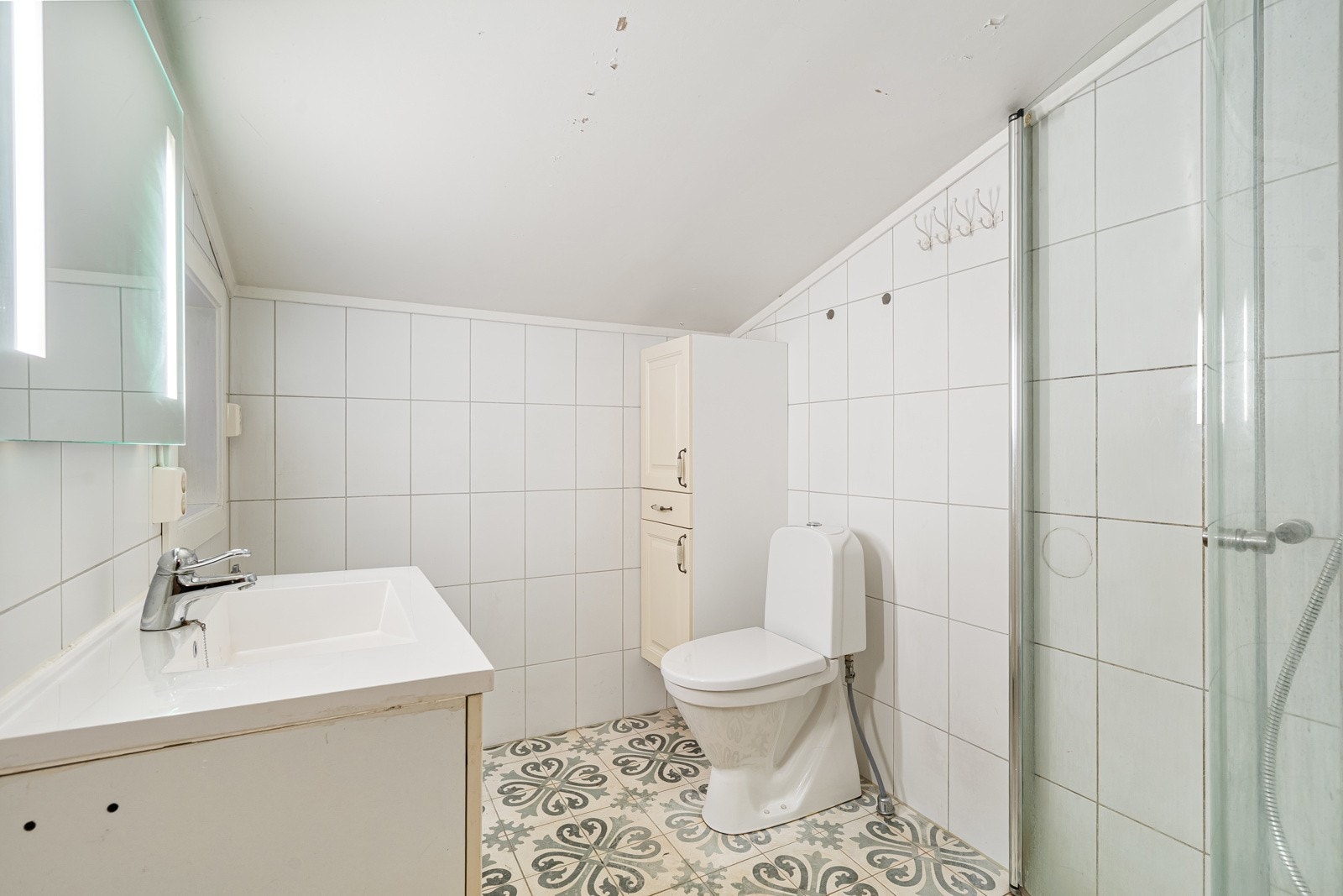 Bad med servant, dusj, toalett og oppevaring. Galleribilde