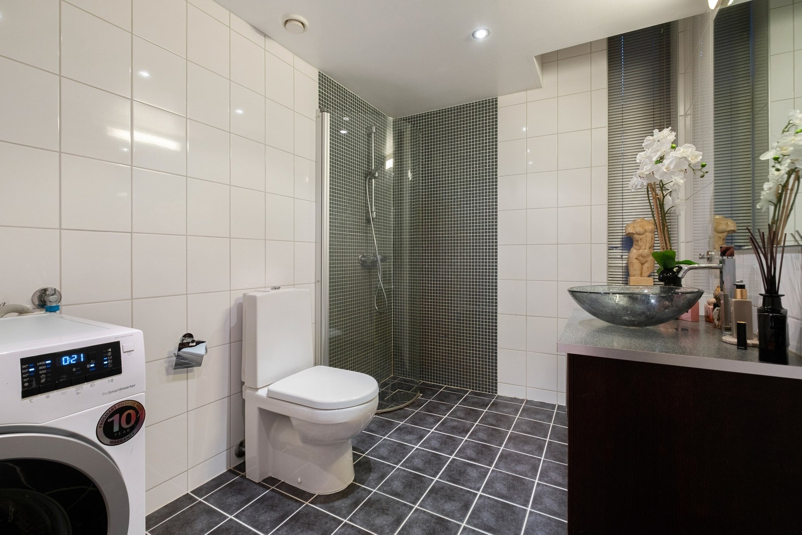 Pent baderom med varme i gulv, dusjnisje, toalett og moderne baderomsinnredning. Galleribilde