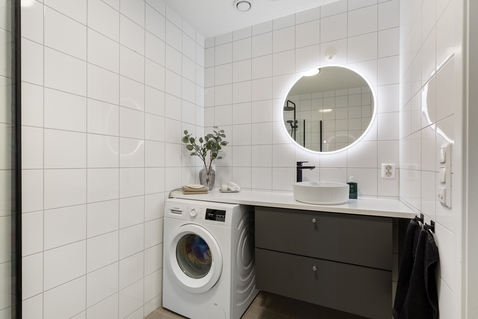 Lekkert flislagt bad med gulvvarme og opplegg for vaskemaskin. Galleribilde