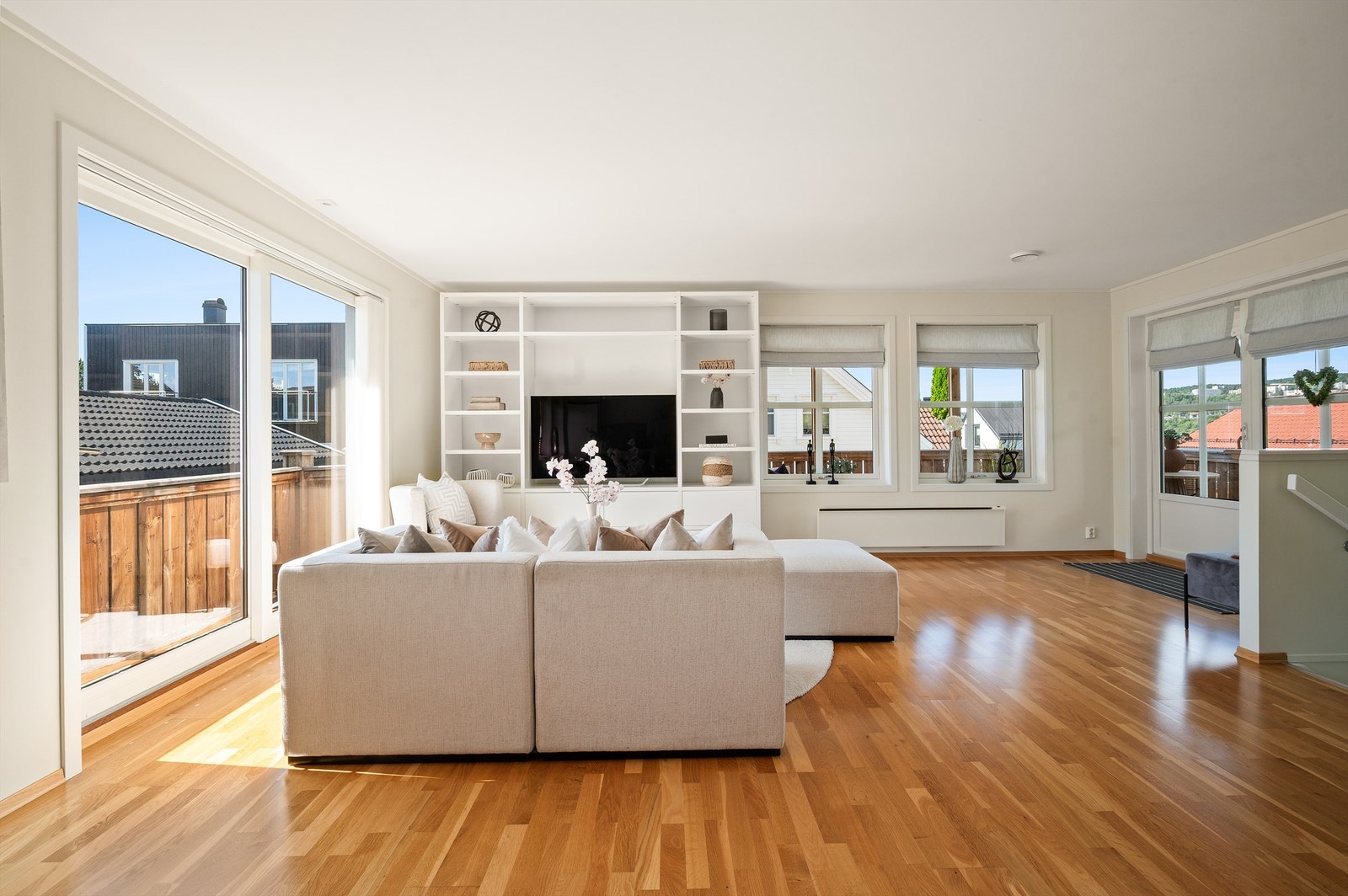 Stuen er lys og moderne med god plass til sofagruppe med tilhørende salongbord og tv-seksjon. Hyllemøblement medfølger boligen Galleribilde