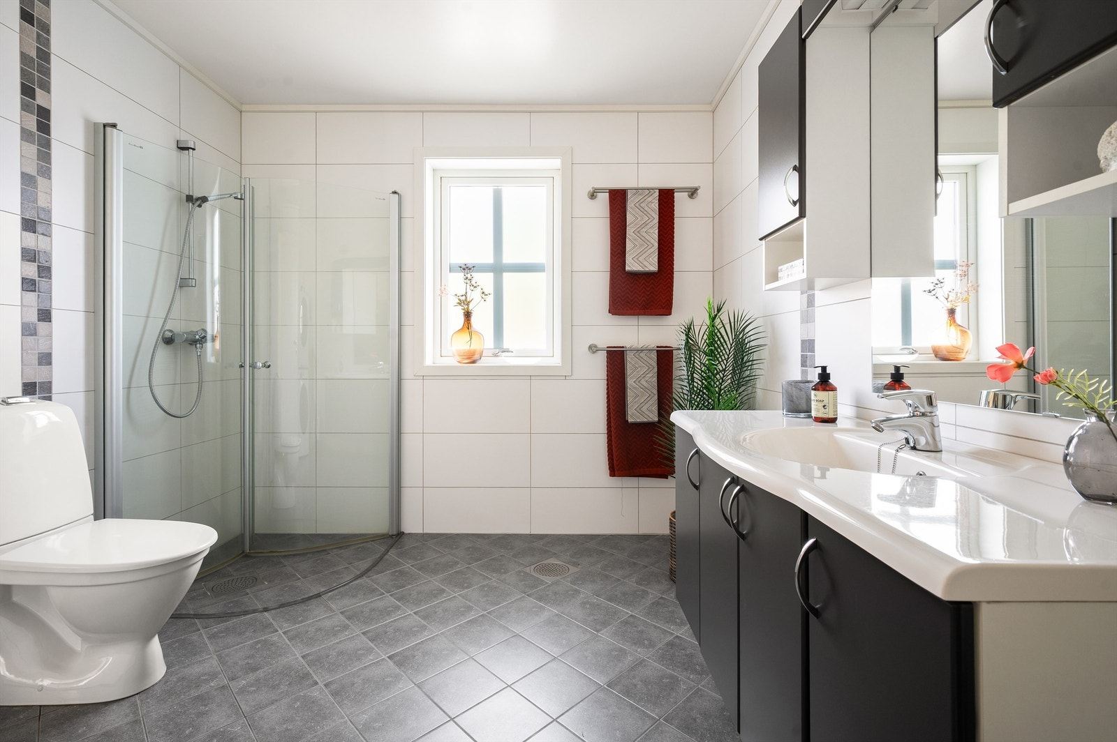 Videre har badet dusjhjørne med svingbare dører og klosett. Galleribilde