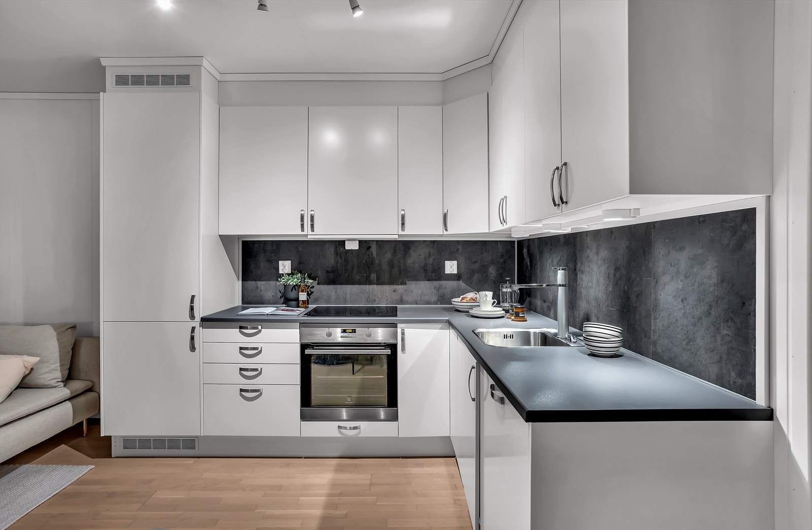 Kjøkkenet har integrerte hvitevarer som koketopp, komfyr, oppvaskmaskin og kjøl/frys. Galleribilde