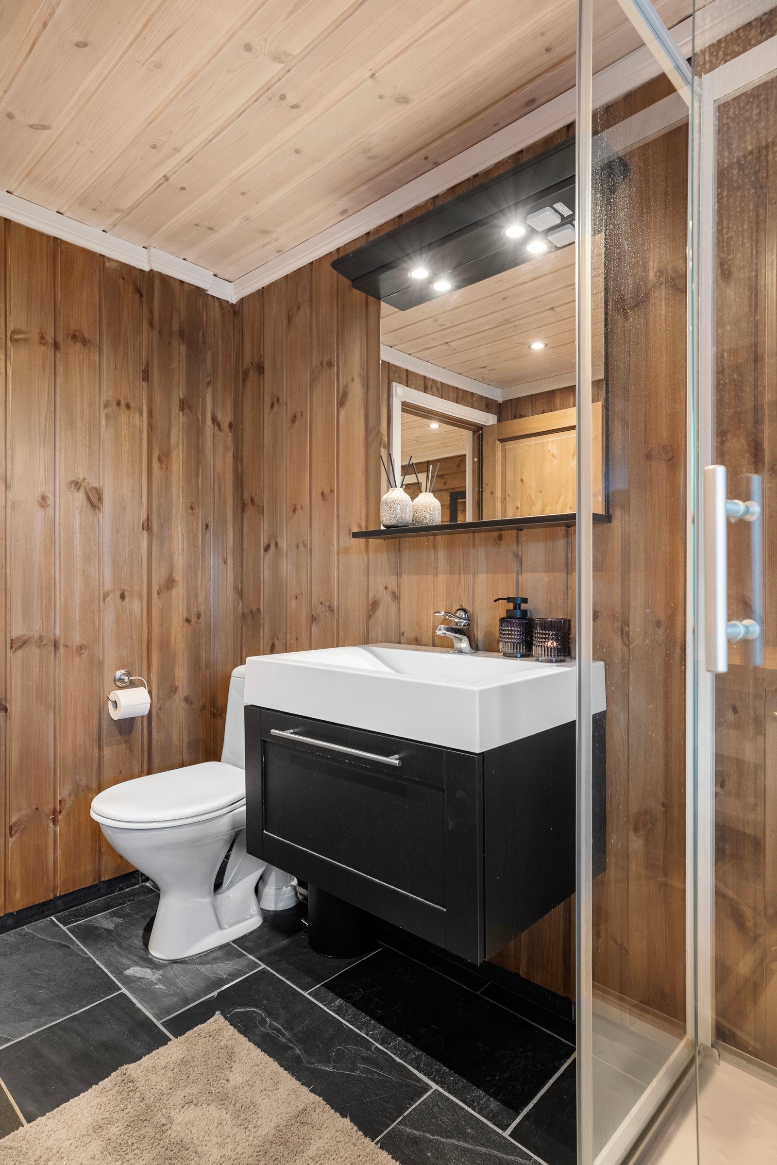 Bad nr 1 har servant i innredning, dusjkabinett og toalett Galleribilde