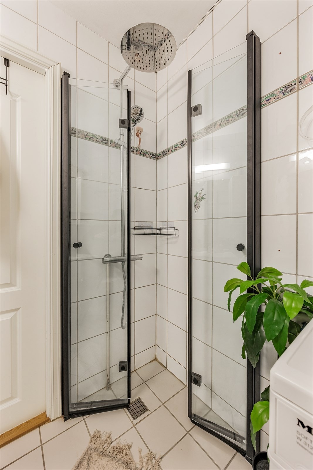 Videre er badet utstyrt med dusjhjørne med innfellbare glassvegger, gulvstående wc og servantinnredning med skuffer og sideskap Galleribilde