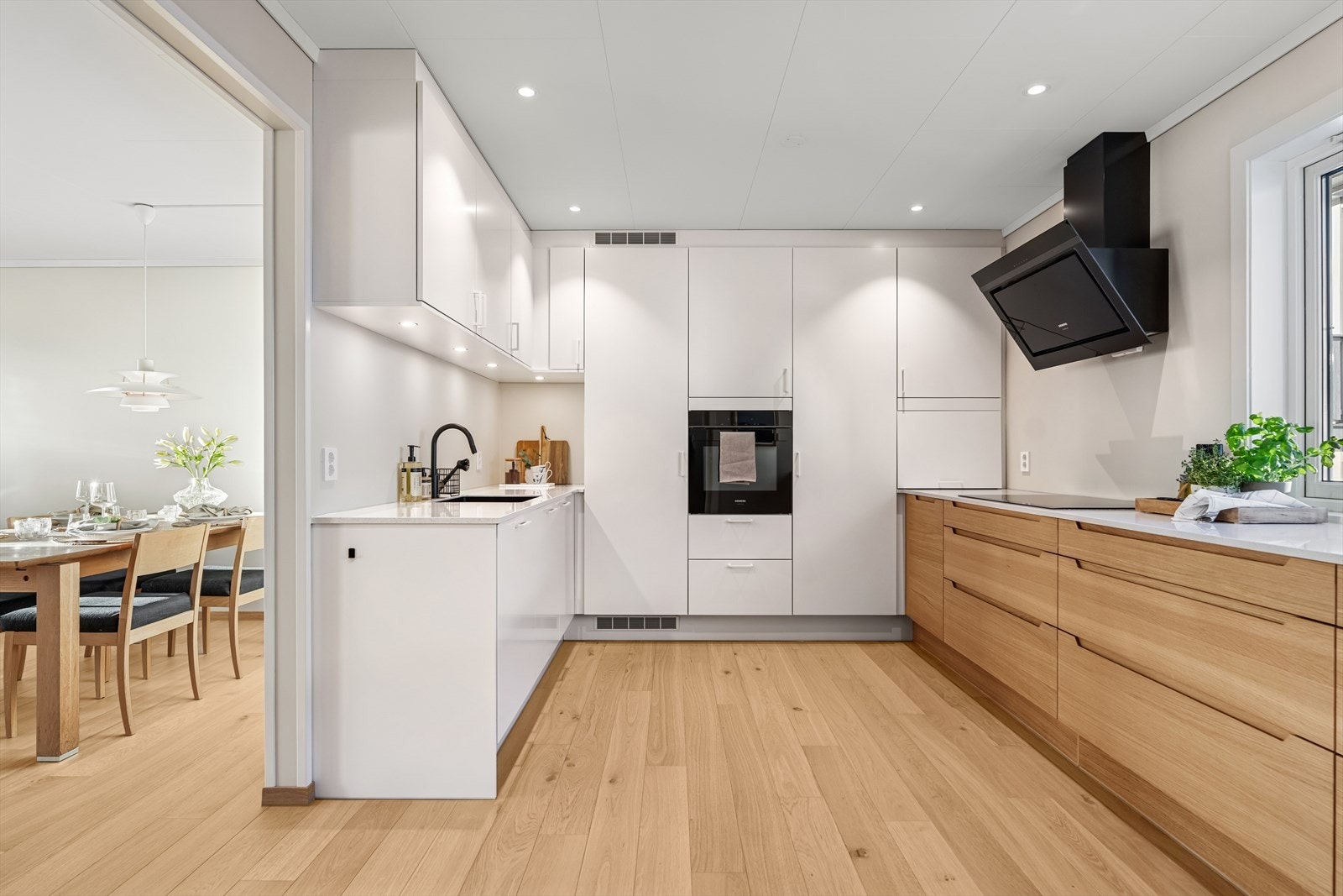 Kjøkkenet var nyttt i 2023 og fremstår som moderne og gjennomført. Gulvet er belagt med parkett, og innredningen fra HTH har en elegant kombinasjon av eik- og hvite fronter, samt en benkeplate i stein som gir et eksklusivt preg. Galleribilde