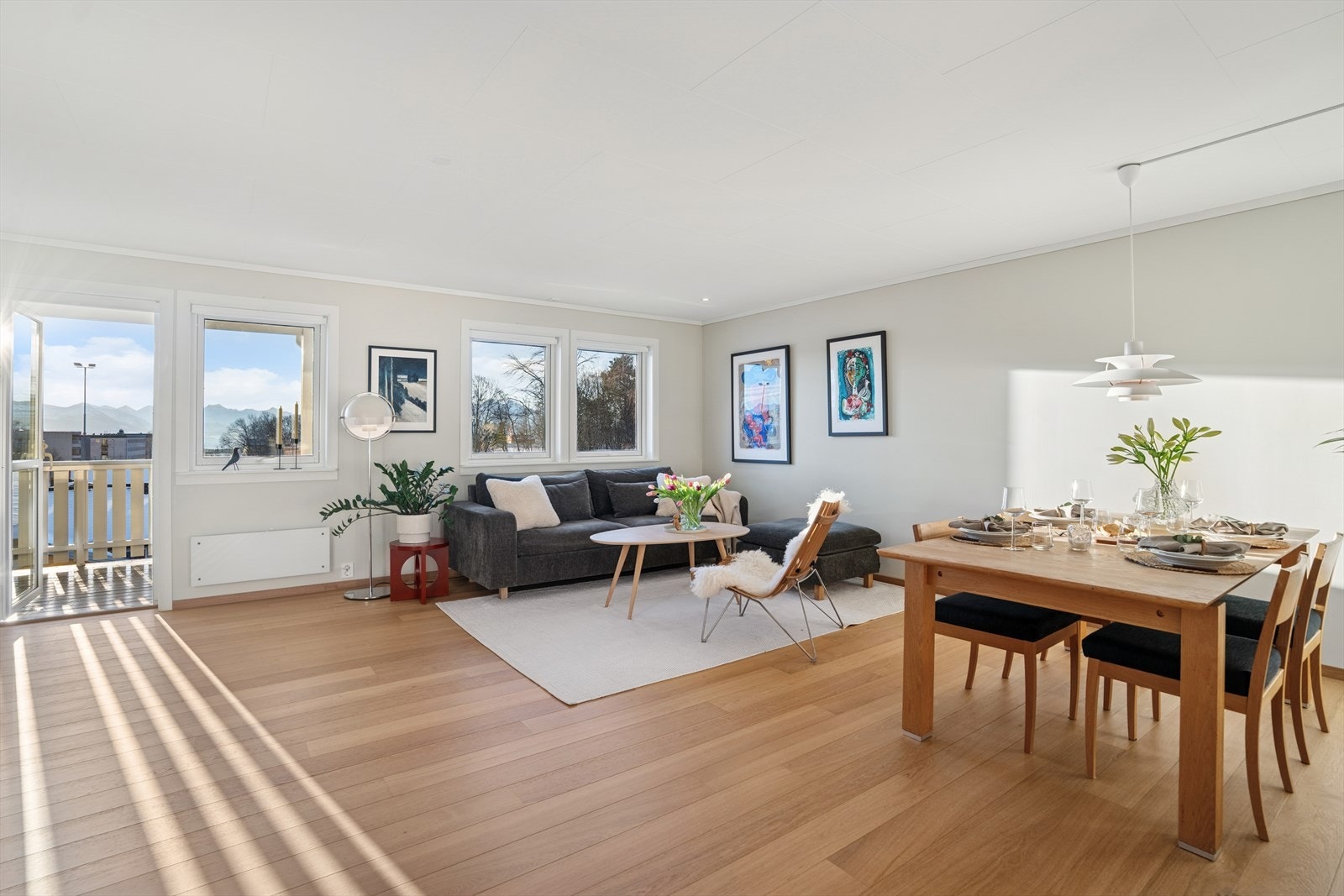 Fra hallen kommer du opp til boligens hjerte - en romslig og lys stue med god plass til møblering og hyggelige soner. Her er det store vindusflater som slipper inn rikelig med dagslys og gir en luftig atmosfære. Galleribilde