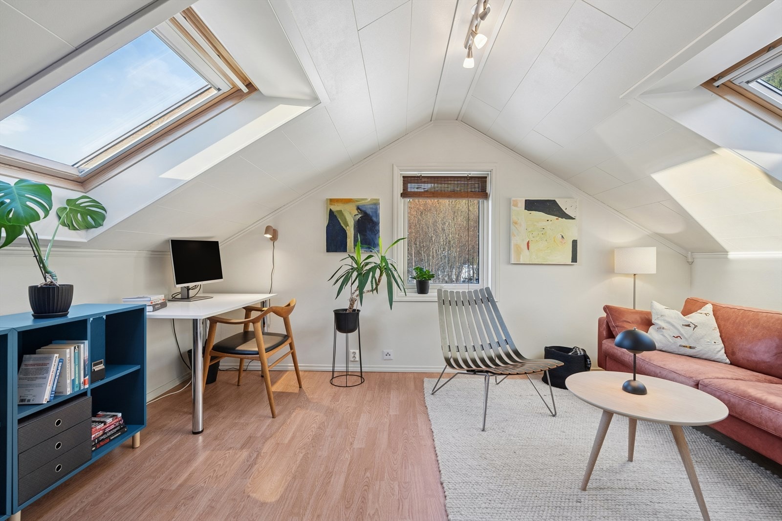 Lyst og pent loftareal med laminatgulv og malte vegger som skaper en praktisk romløsning. Galleribilde