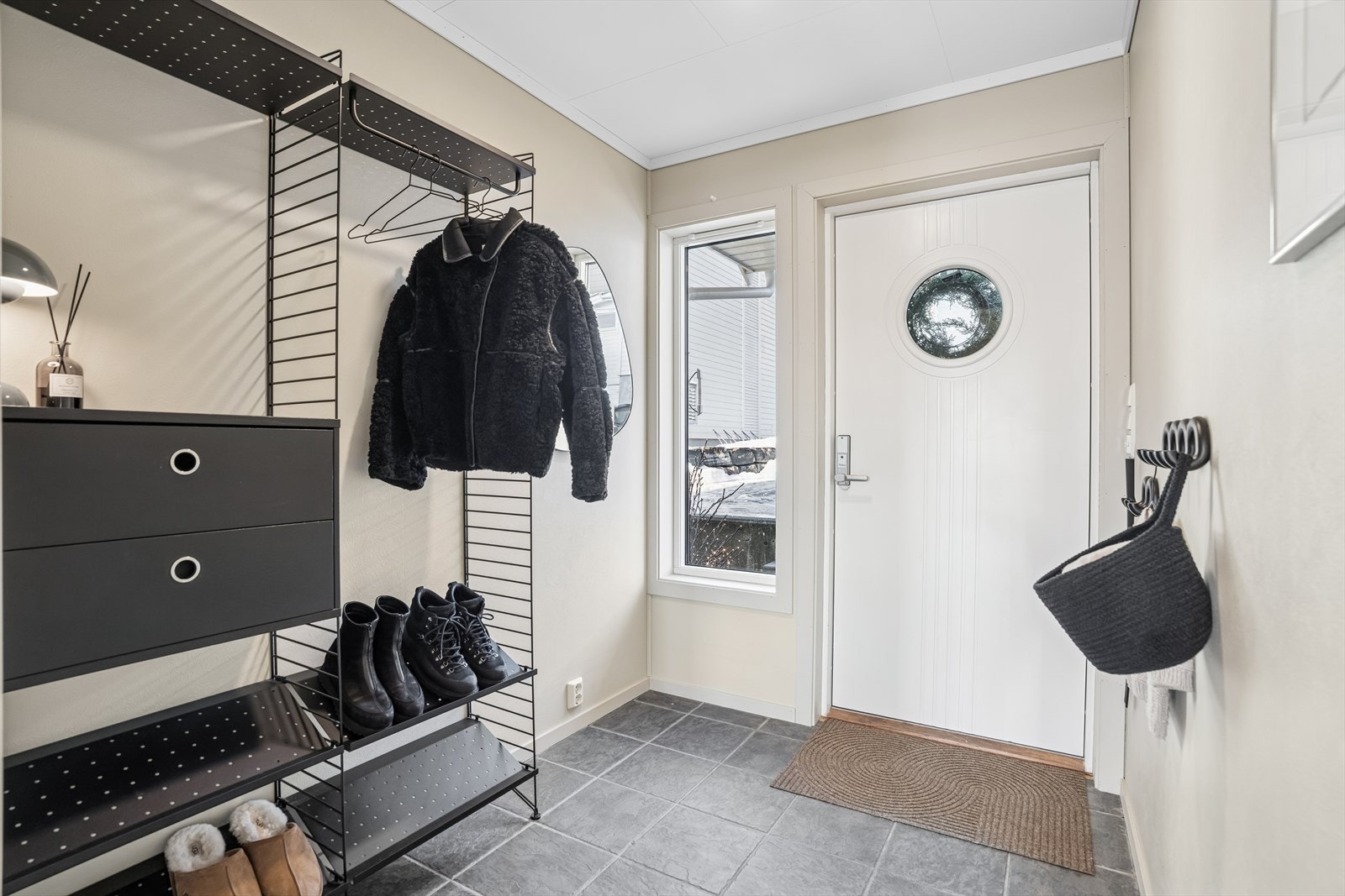 Innenfor døren venter en lys og romslig entré med god plass til yttertøy og sko. Sidevindu gir fint lysinnslipp, og flislagt gulv med varmekabler gir en praktisk og komfortabel inngang. Ytterdøren har nøkkelfritt låsesystem for enkel tilgang. Galleribilde