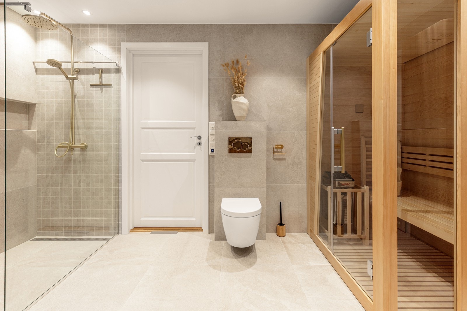 En frittstående badstue og vegghengt toalett kompletterer rommet. Galleribilde