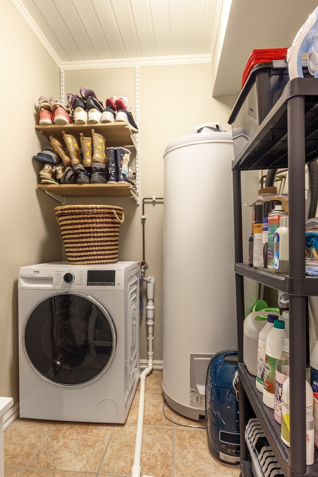 Separat og praktisk vaskerom med opplegg for vaskemaskin og boligens varmtvannsbereder. Galleribilde