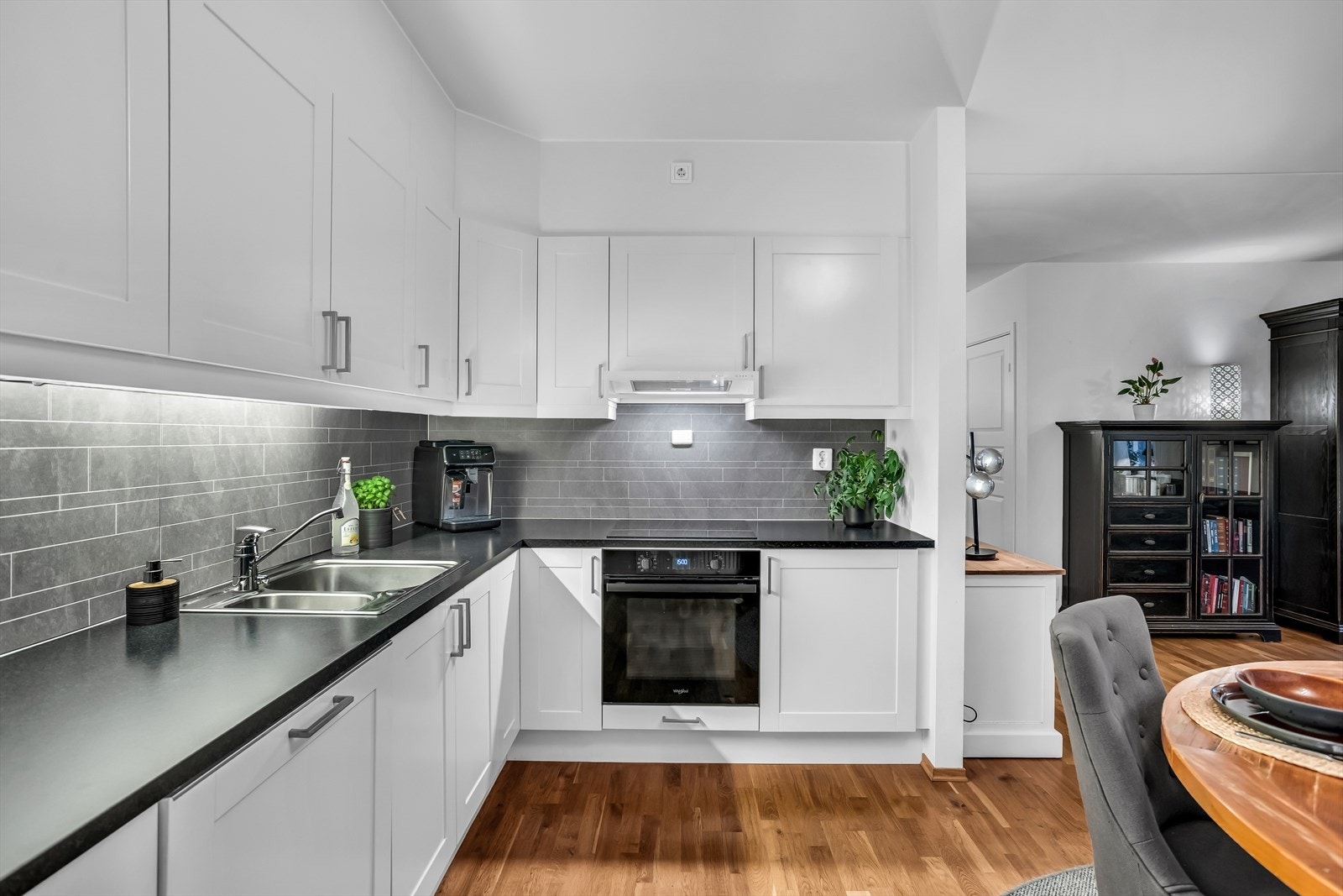 Innredningen har glatte, hvite fronter og en mørk laminatbenkeplate. Galleribilde