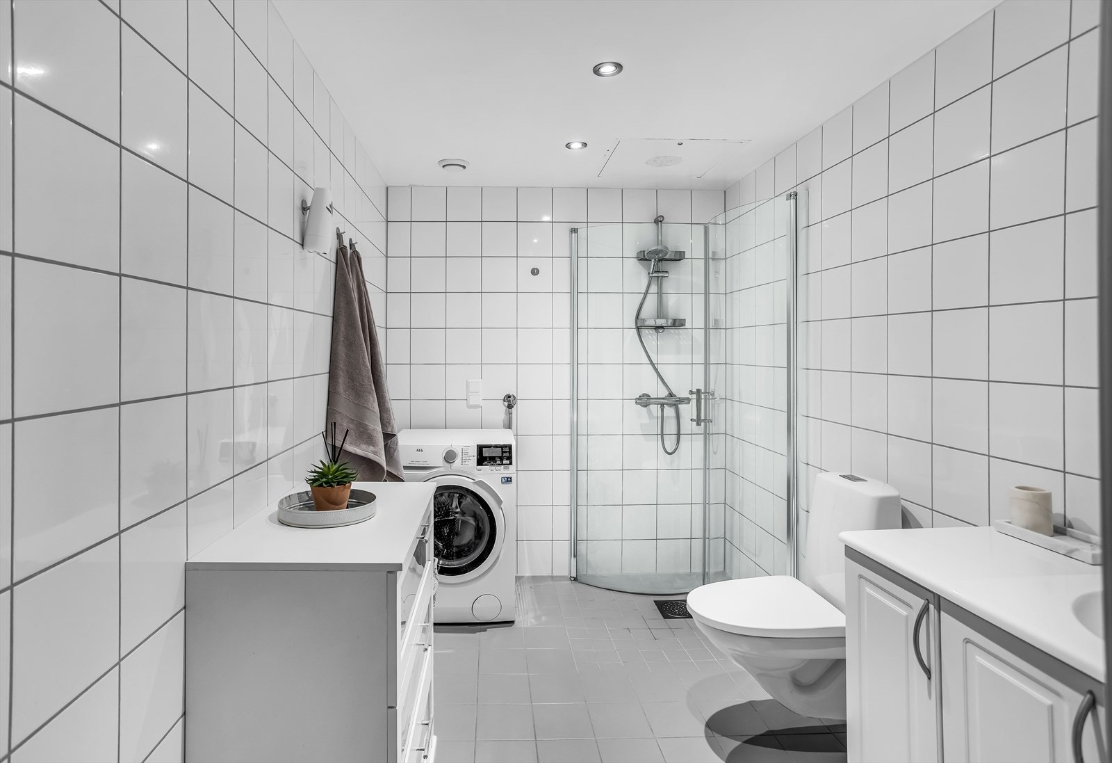 Her er det dusjhjørne med innfellbare glassdører og opplegg for vaskemaskin. Galleribilde