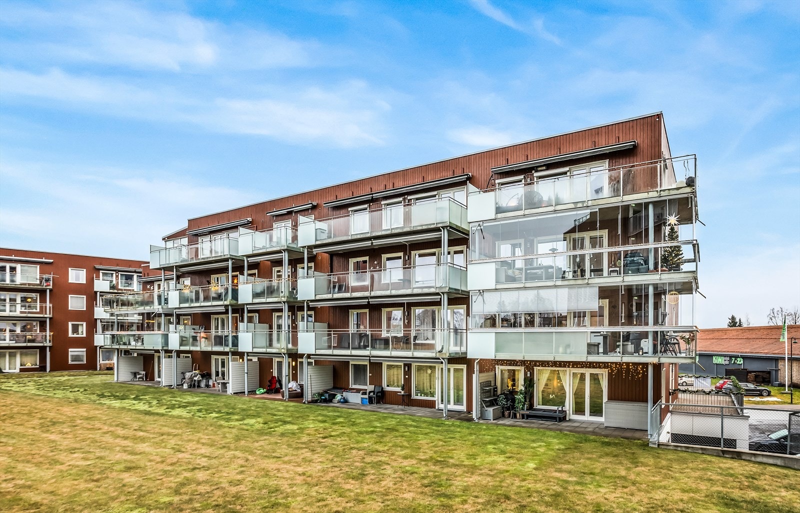 Bygget har en moderne fasade med en kombinasjon av trepanel og store glassflater. Galleribilde