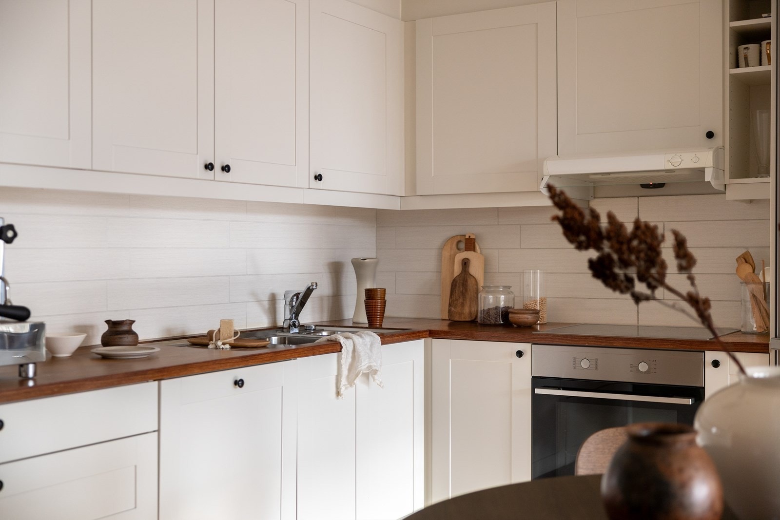 Kjøkkeninnredningen har et stilrent og moderne design med glatte fronter og heltre benkeplate. Galleribilde