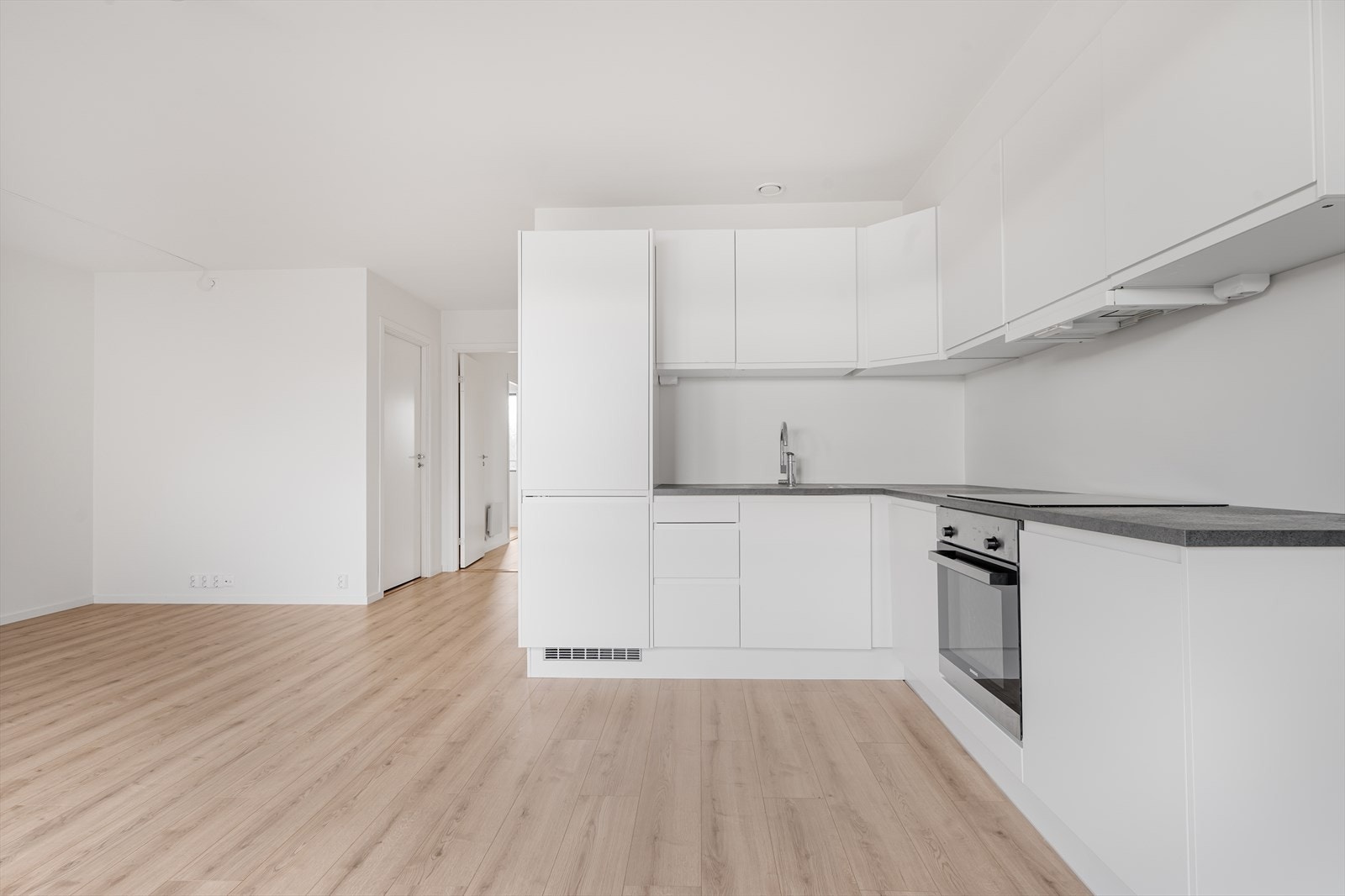 Kjøkkeninnredningen har integrert koketopp, stekeovn, oppvaskmaskin og kombi kjøl/frys. Galleribilde