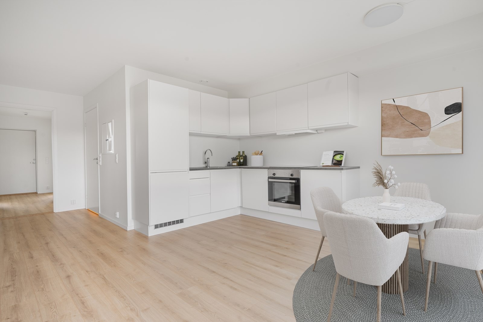 Kjøkkenet er i praktisk L-form og har hvite, slette fronter og laminat benkeplate. Digitalt møblert. Galleribilde