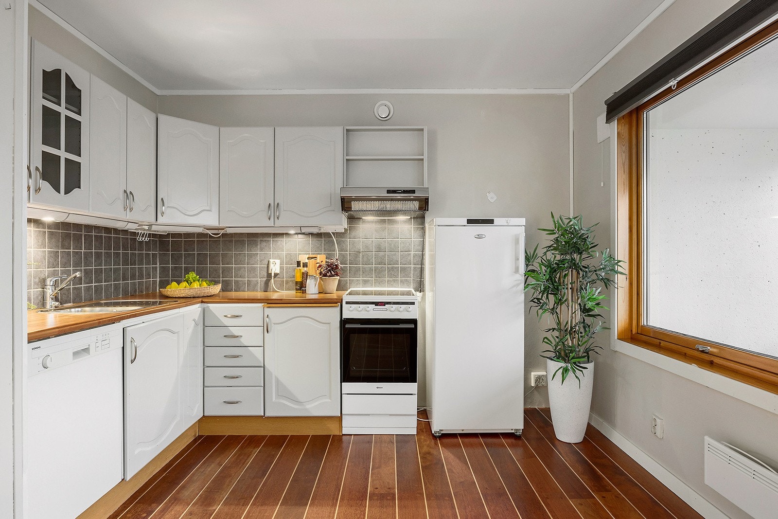 Kjøkken med spiseplass - hvit innredning og godt med skap Galleribilde