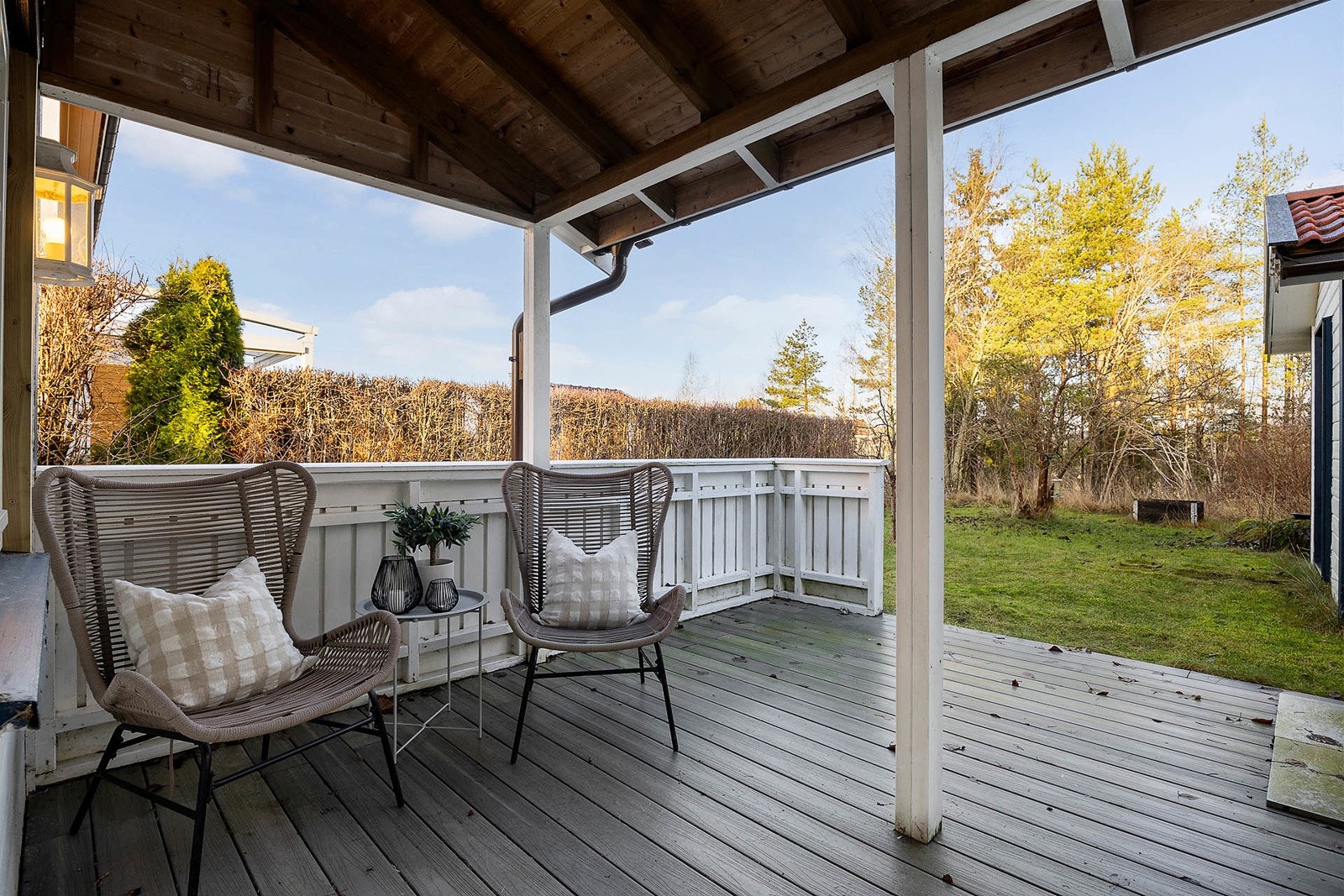 Hyggelig, overbygd terrasse med god plass til sittegruppe. Terrassen gir fine muligheter for avslapping og sosiale stunder i rolige omgivelser, og fungerer som et naturlig bindeledd mellom boligen og den romslige hagen. Galleribilde