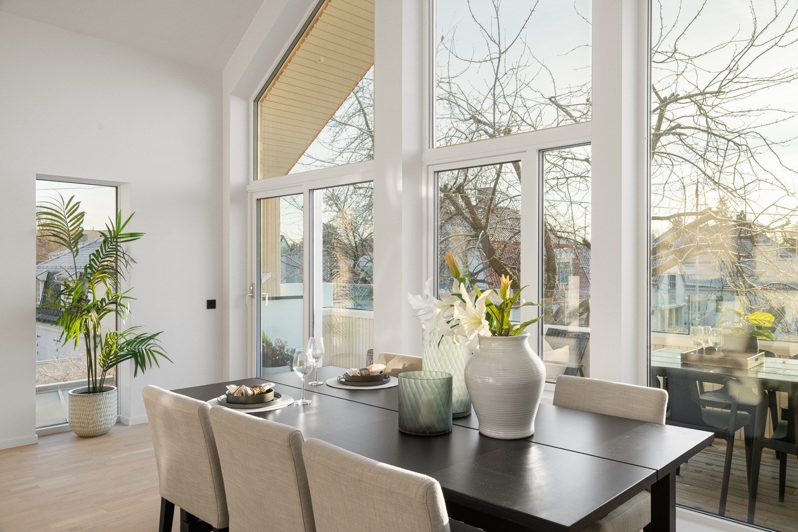 Spisestuen ligger perfekt til ved det store vinduet, og den åpne løsningen mot kjøkkenet skaper et sosialt rom hvor samtaler og måltider flyter naturlig sammen. Galleribilde