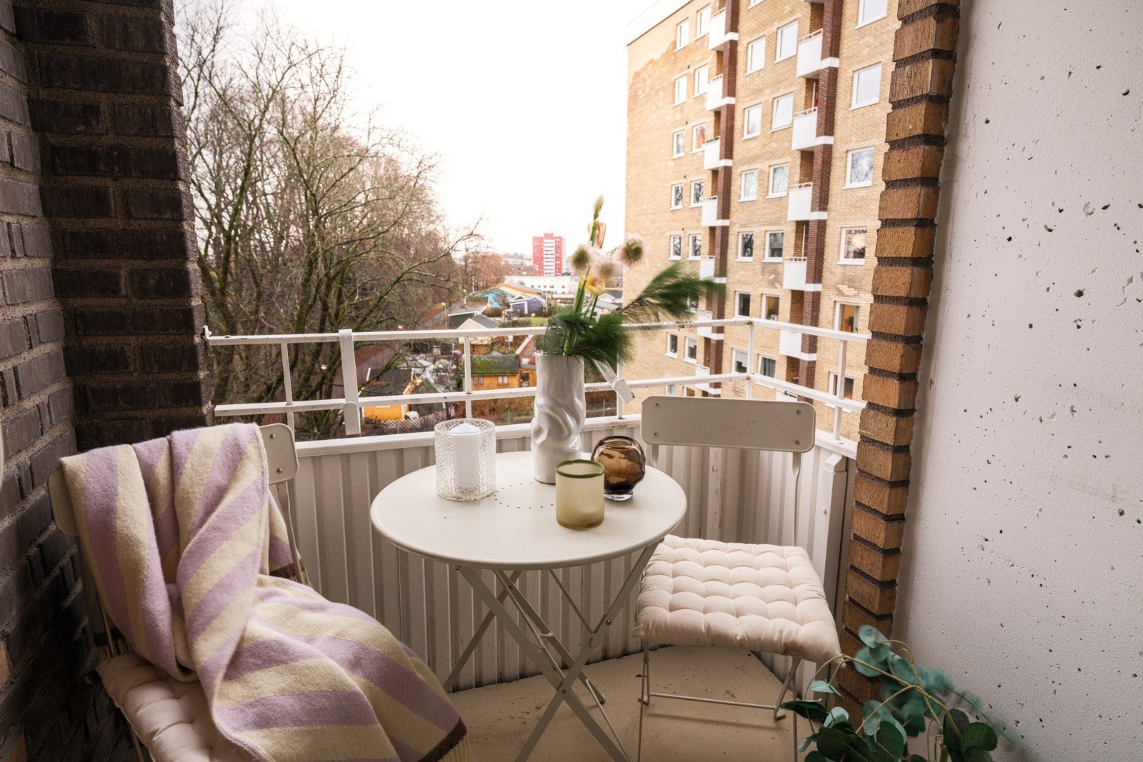 Balkongen er overbygget, har støpt betongdekke på gulv og plass til et hyggelig kafésett. Galleribilde