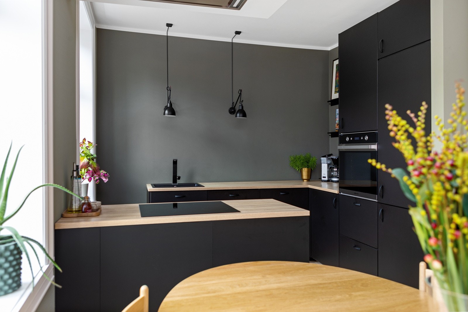 Du har god skap- og benkeplass i innredningen som har sorte glatte fronter i matt utførelse og laminert benkeplate med nedsenket oppvaskkum og sort armatur fra Teka. Galleribilde