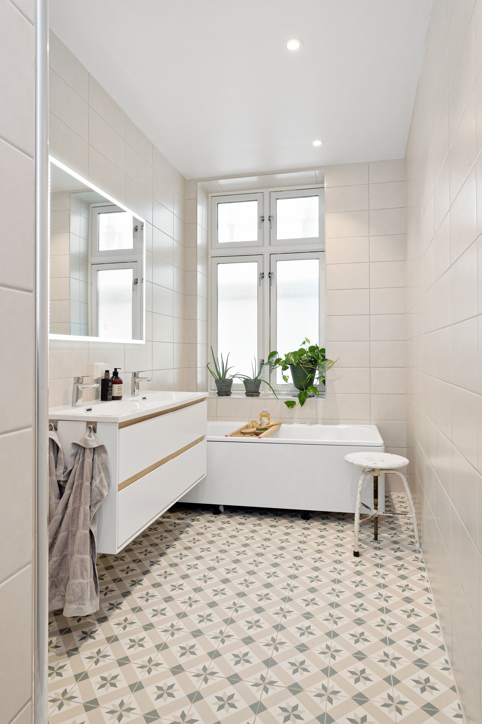 Baderommet er utstyrt med både et badekar ved vinduet og dusjhjørne med glassdører og regnfallsdusj. Galleribilde