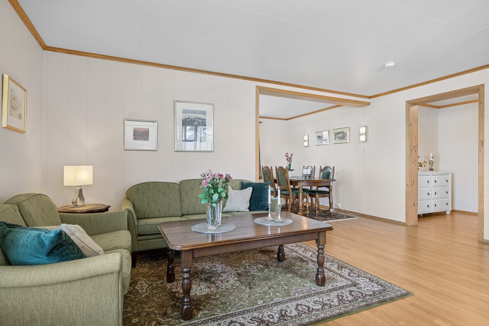 Den delvis åpne løsningen mot kjøkkenet skaper en sosial og praktisk sone, hvor det også er rikelig plass til spisebord - perfekt for både hverdagsmåltider og hyggelige middager med gjester. Galleribilde